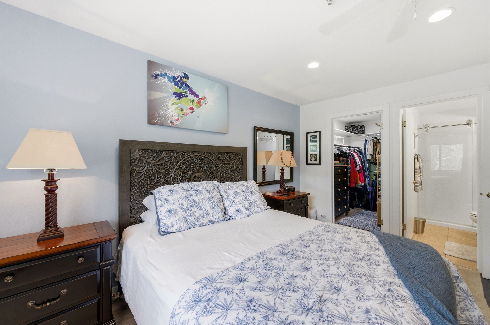 Bedroom featuring a detailed wood headboard, light blue accent wall, recessed lighting, and a ceiling fan