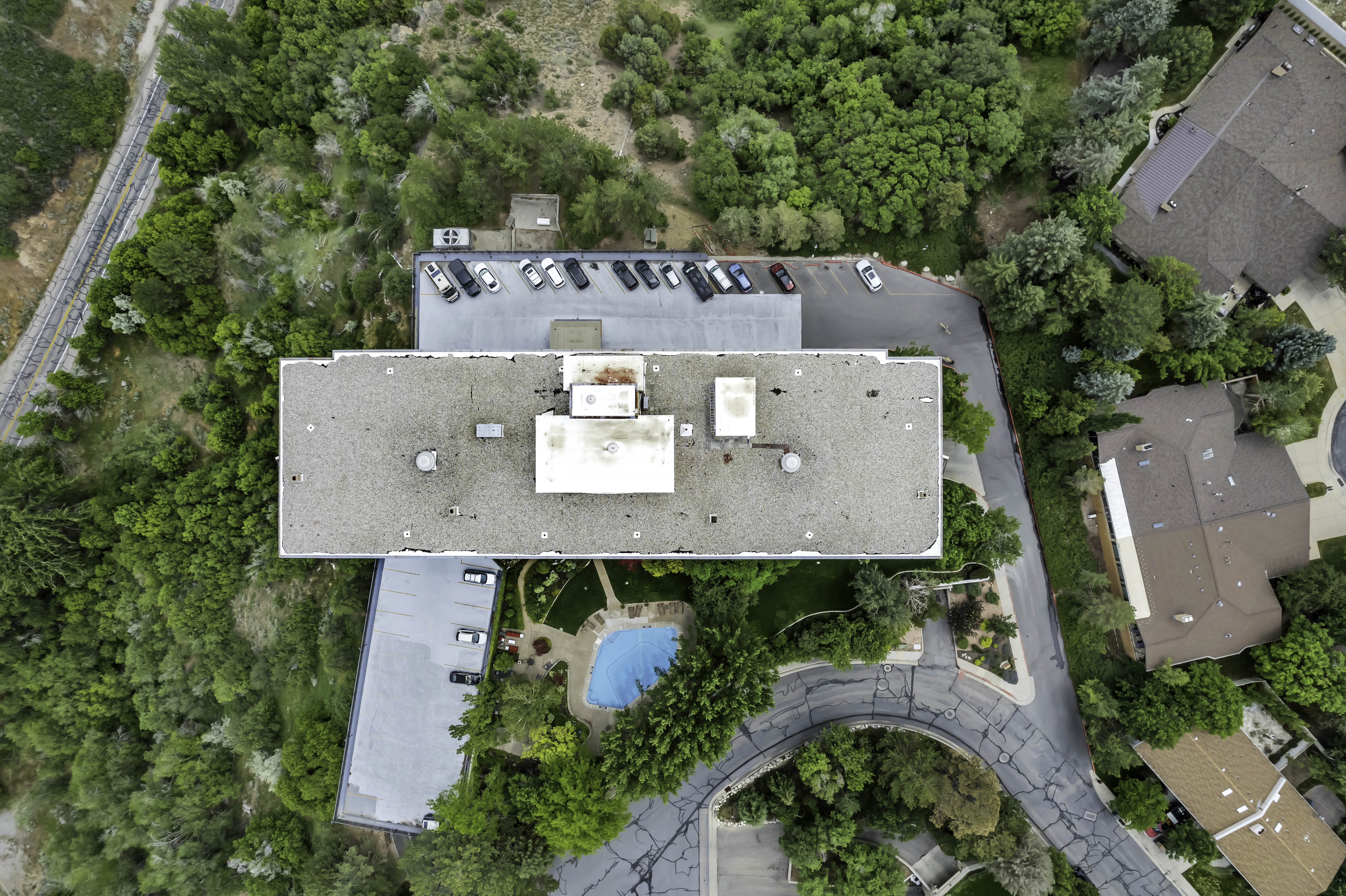 Aerial perspective showcasing the parking and common area pool and gardens