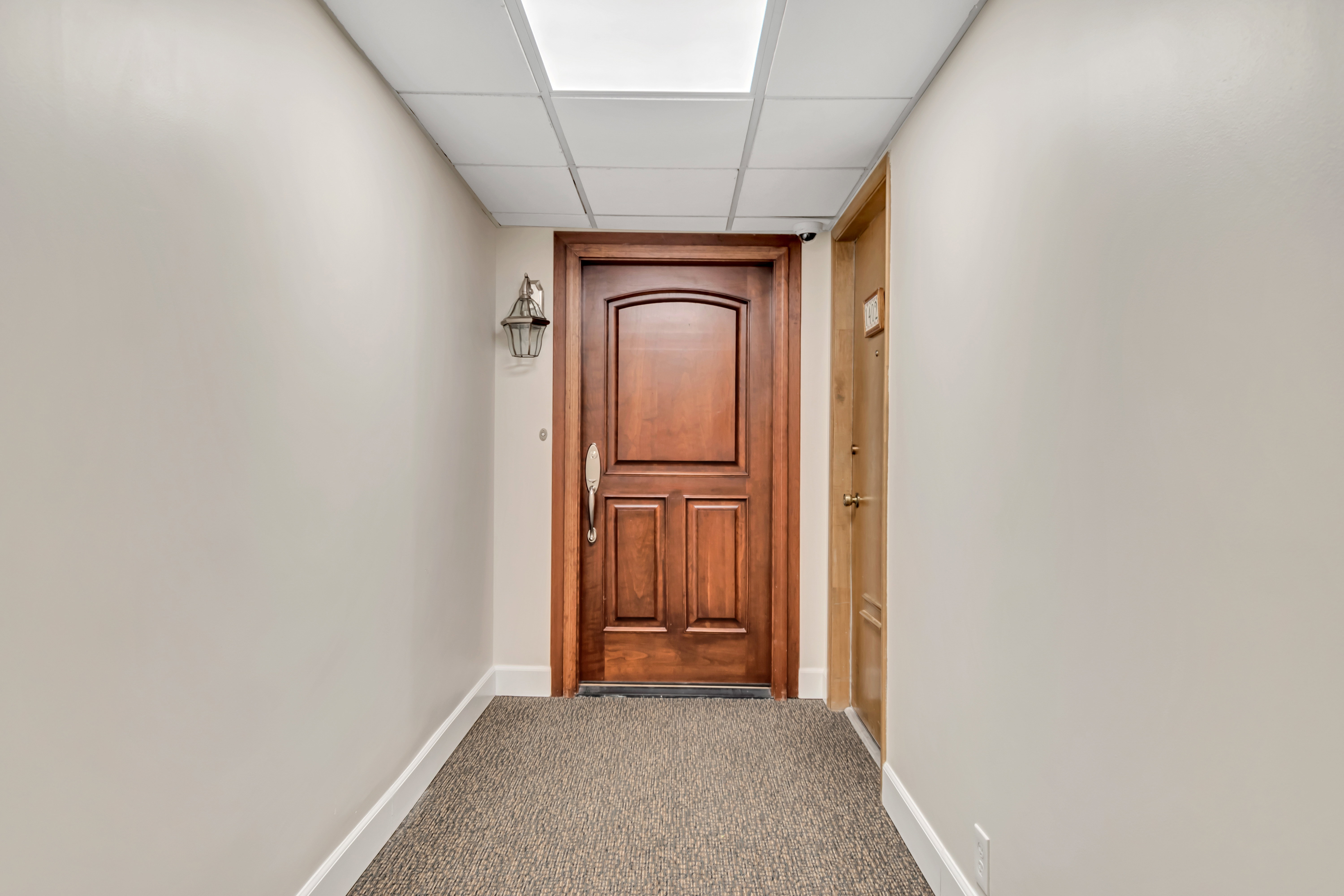 Solid cherry wood entry door featuring arched paneling and brushed nickel hardware