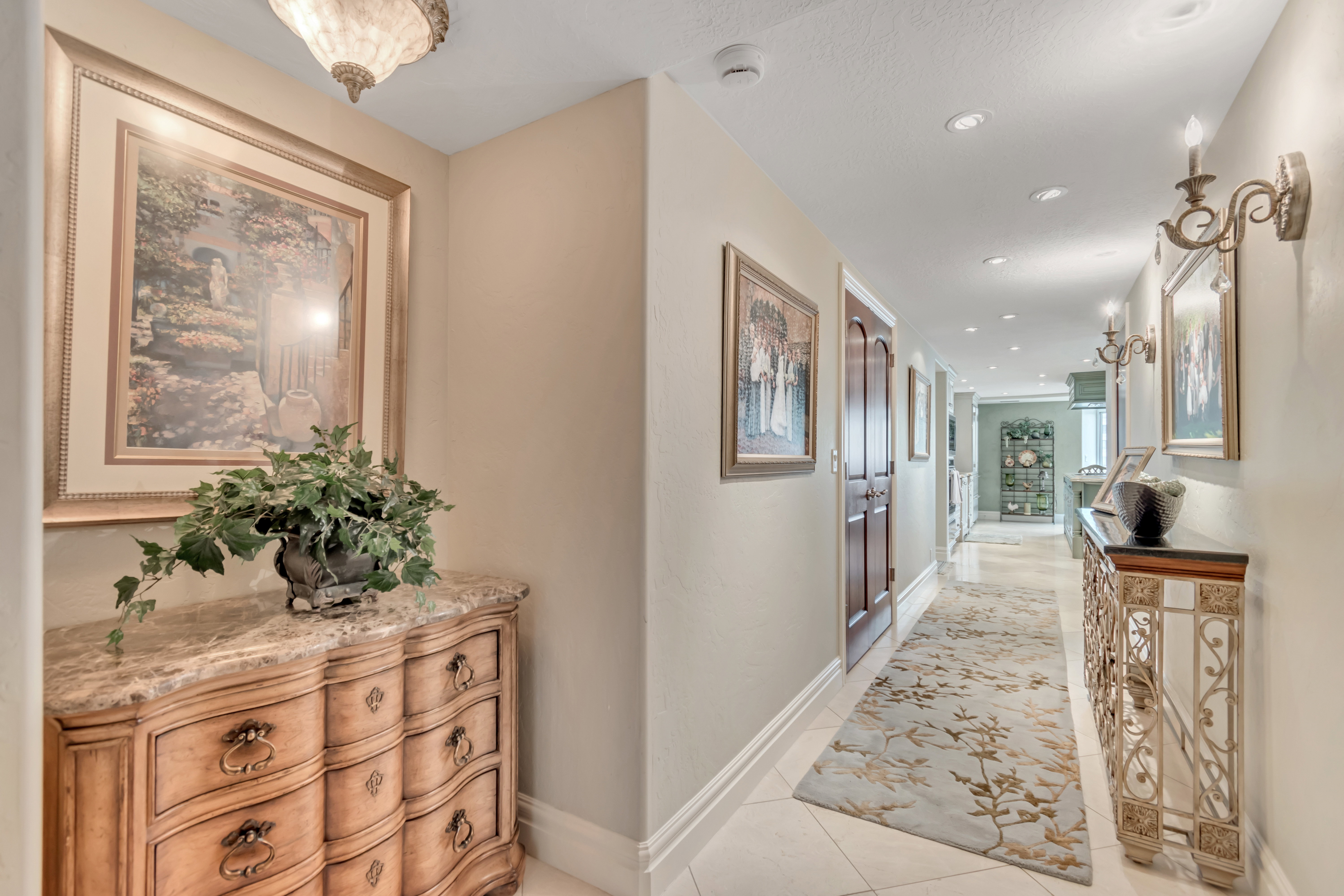 Hallway featuring recessed lighting, decorative wall sconces, and light-toned wall paint