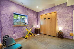 Room featuring textured purple walls, recessed lighting, and a built-in wood-paneled Murphy bed