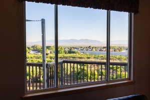 Expansive window featuring a distant mountain range, community landscape, and vineyard scenery