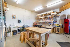Spacious garage featuring a concrete floor, built-in utility sink, and overhead fluorescent lighting