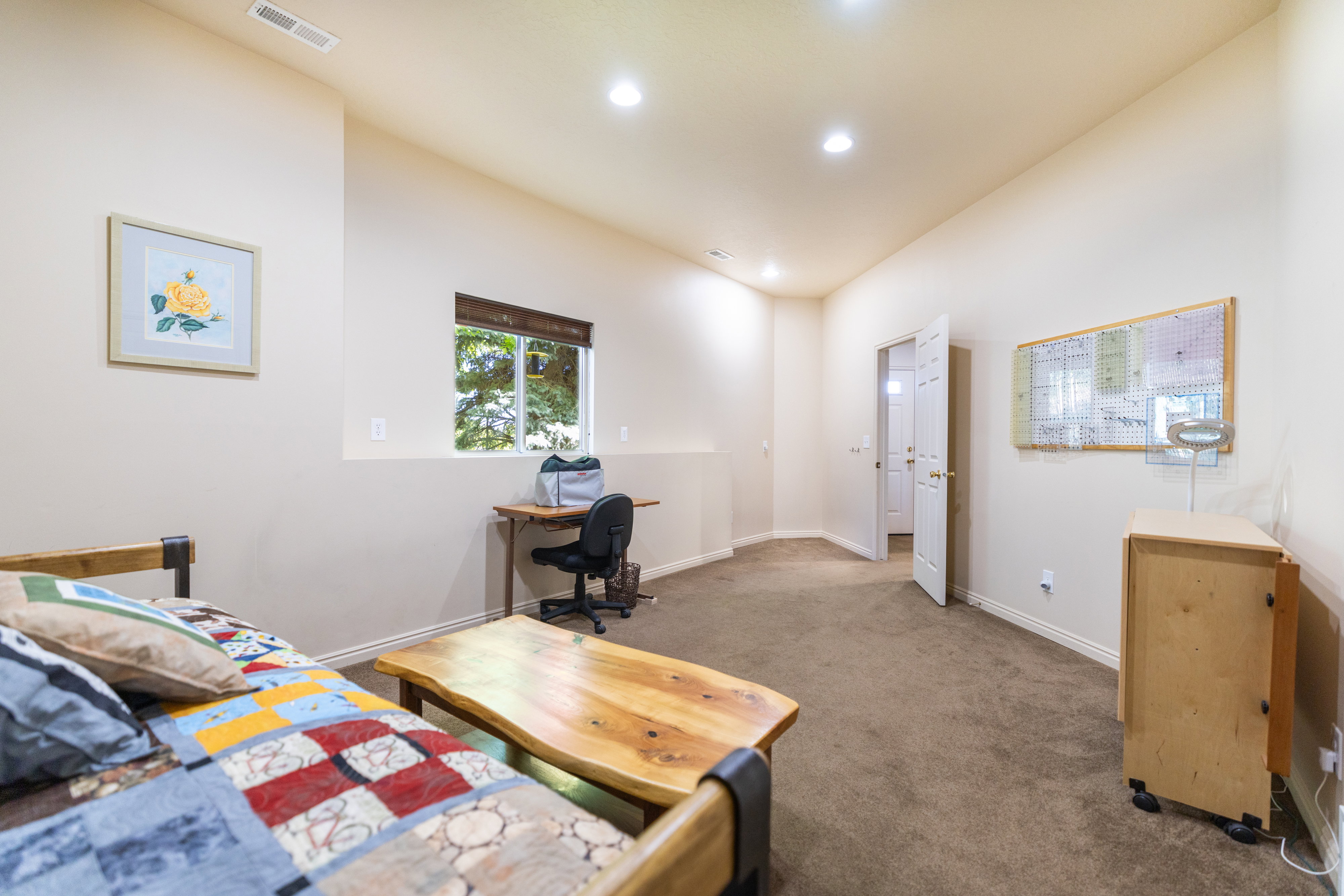 Carpeted room with recessed lighting and a window featuring a brown blind