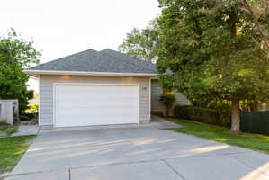 Single-story residence featuring light gray siding and a dark shingle roof