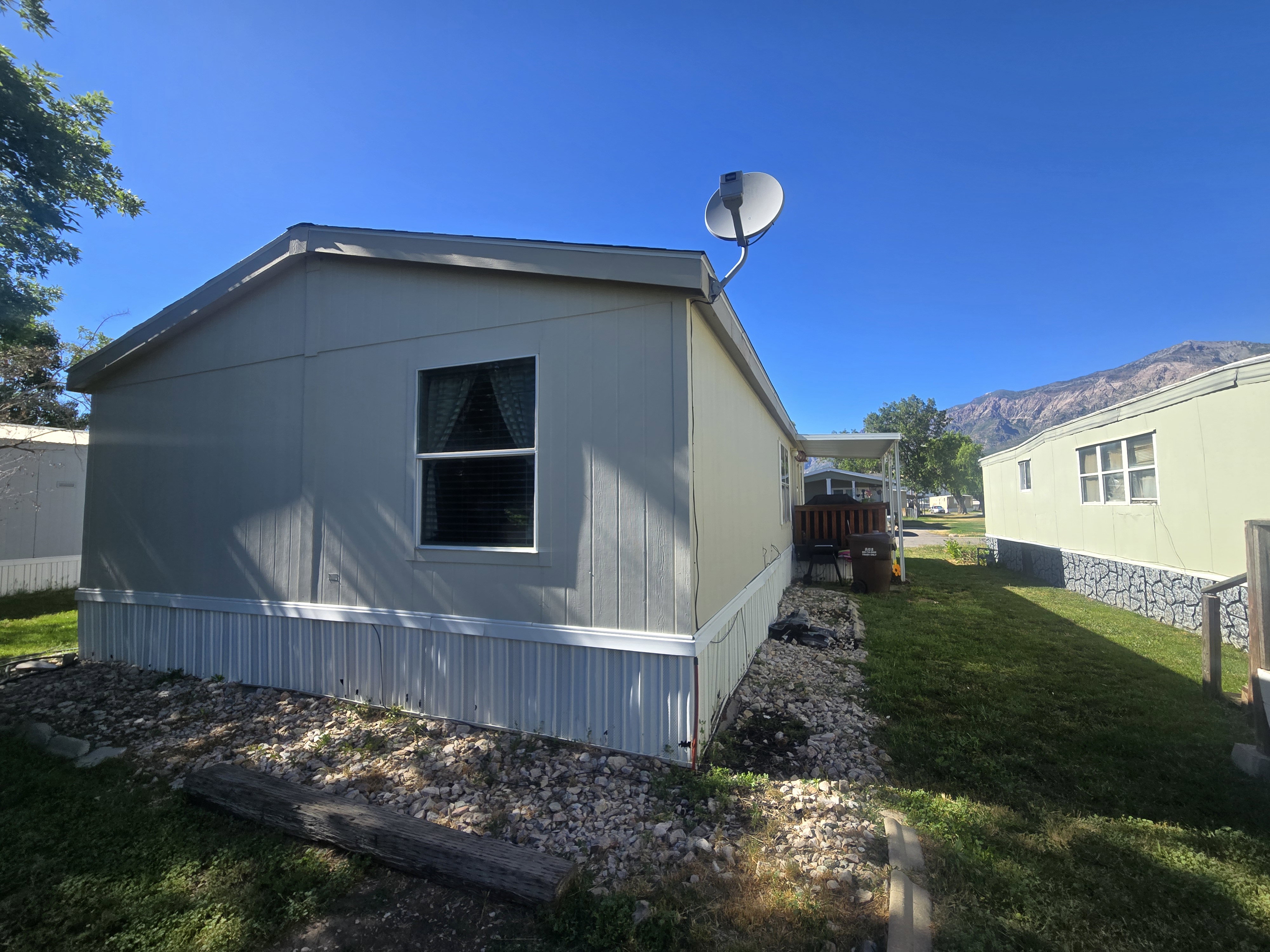 Exterior siding with white trim and a gravel border