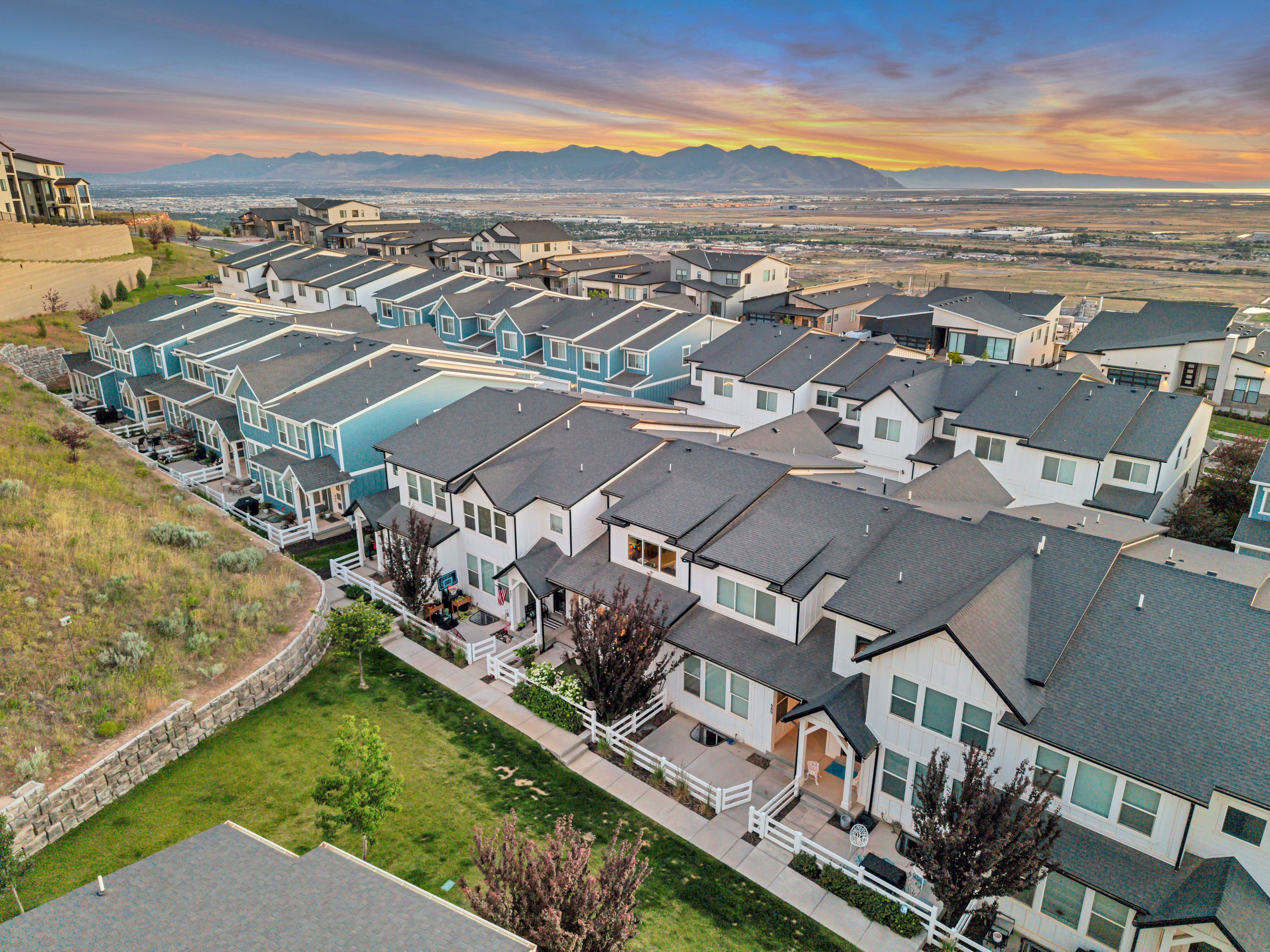 Modern townhome community featuring contemporary architectural styles, dark shingle roofing, and contrasting light-colored exteriors