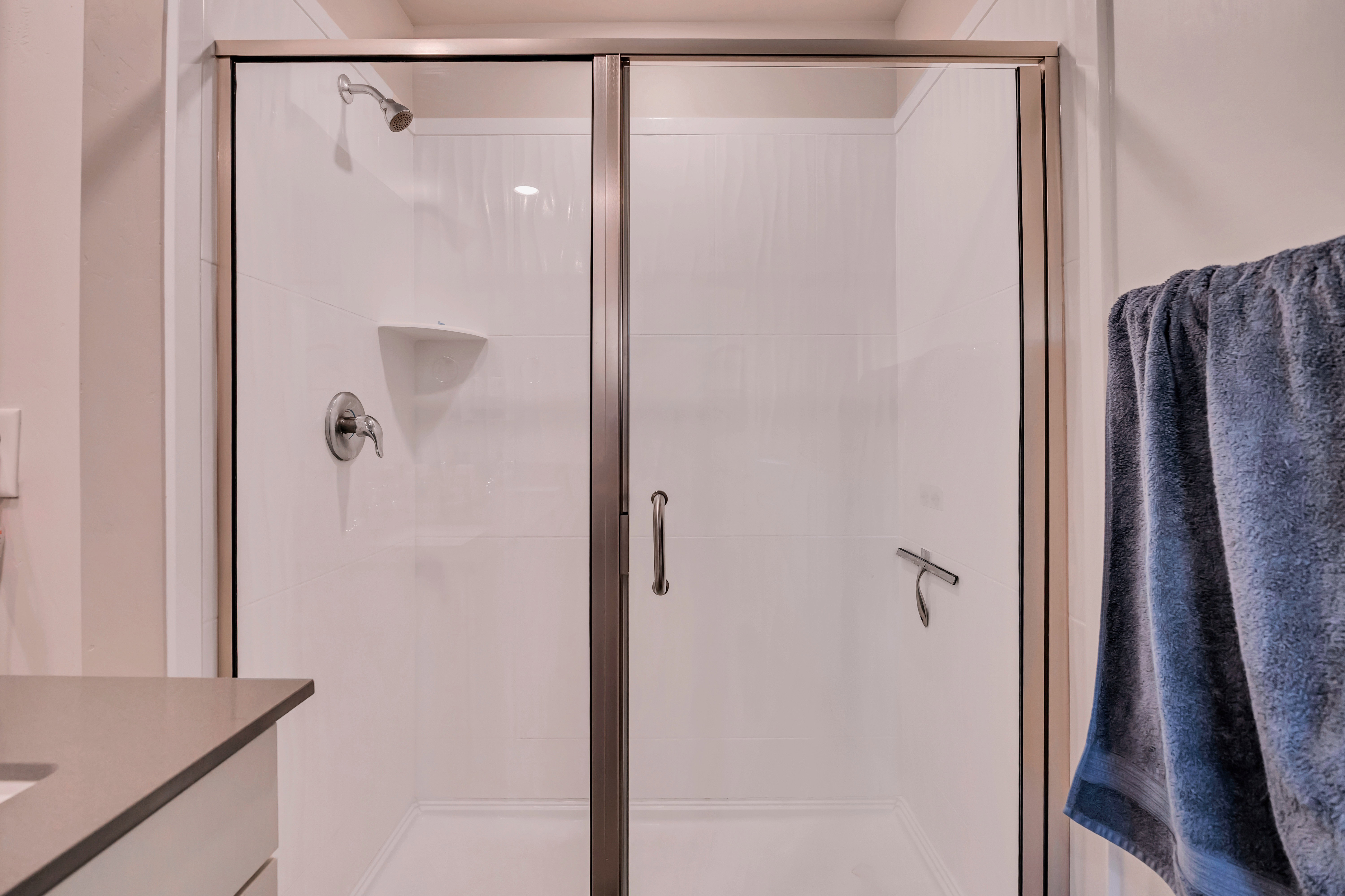 Shower enclosure featuring clear glass panels with bronze-finish framing