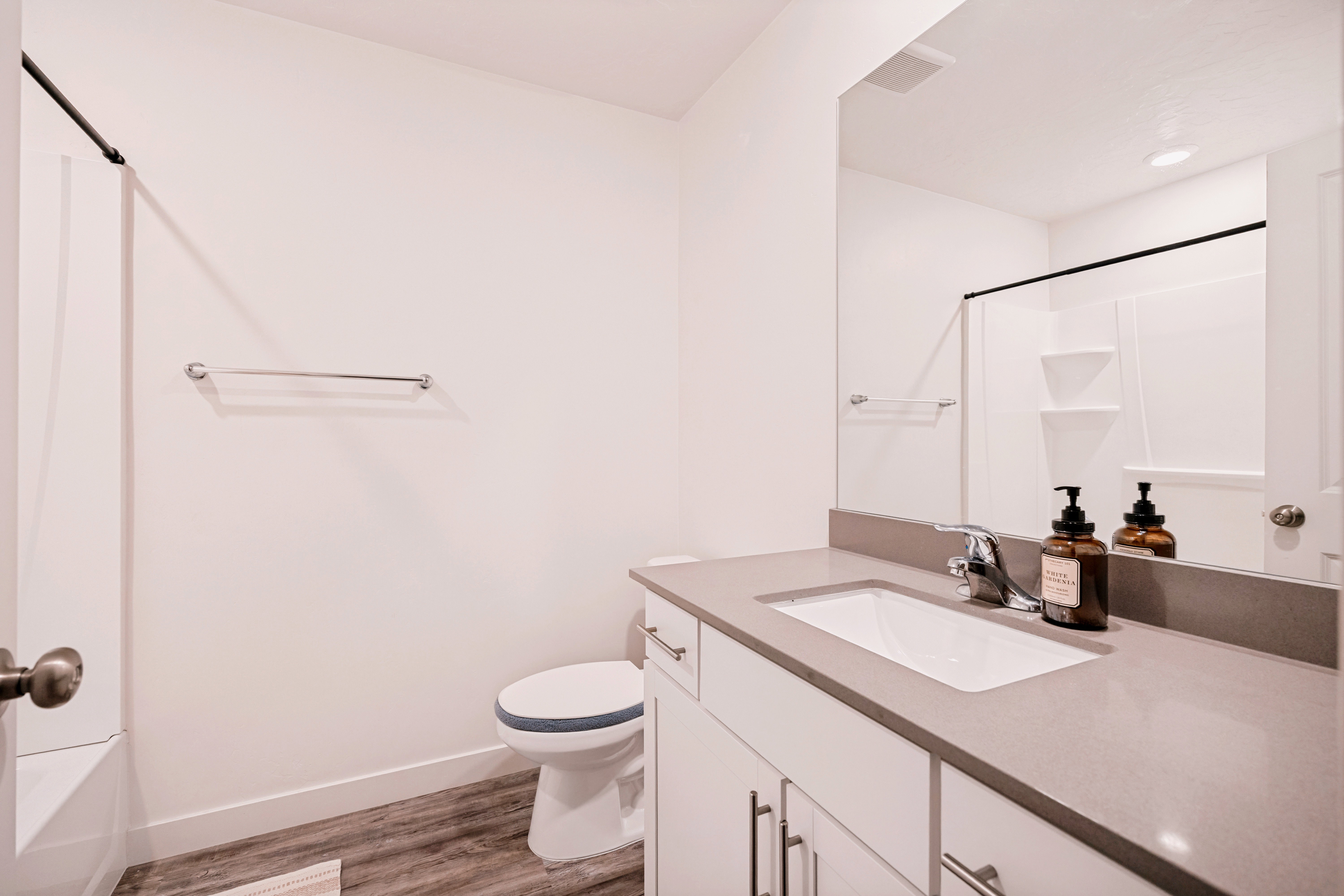 Bathroom featuring a vanity with an integrated sink, a gray countertop, and white cabinetry