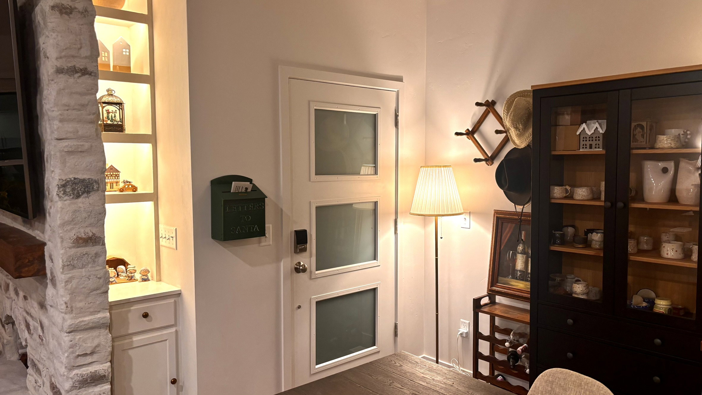 White paneled door with three frosted glass panels, featuring a satin nickel doorknob and smart lock