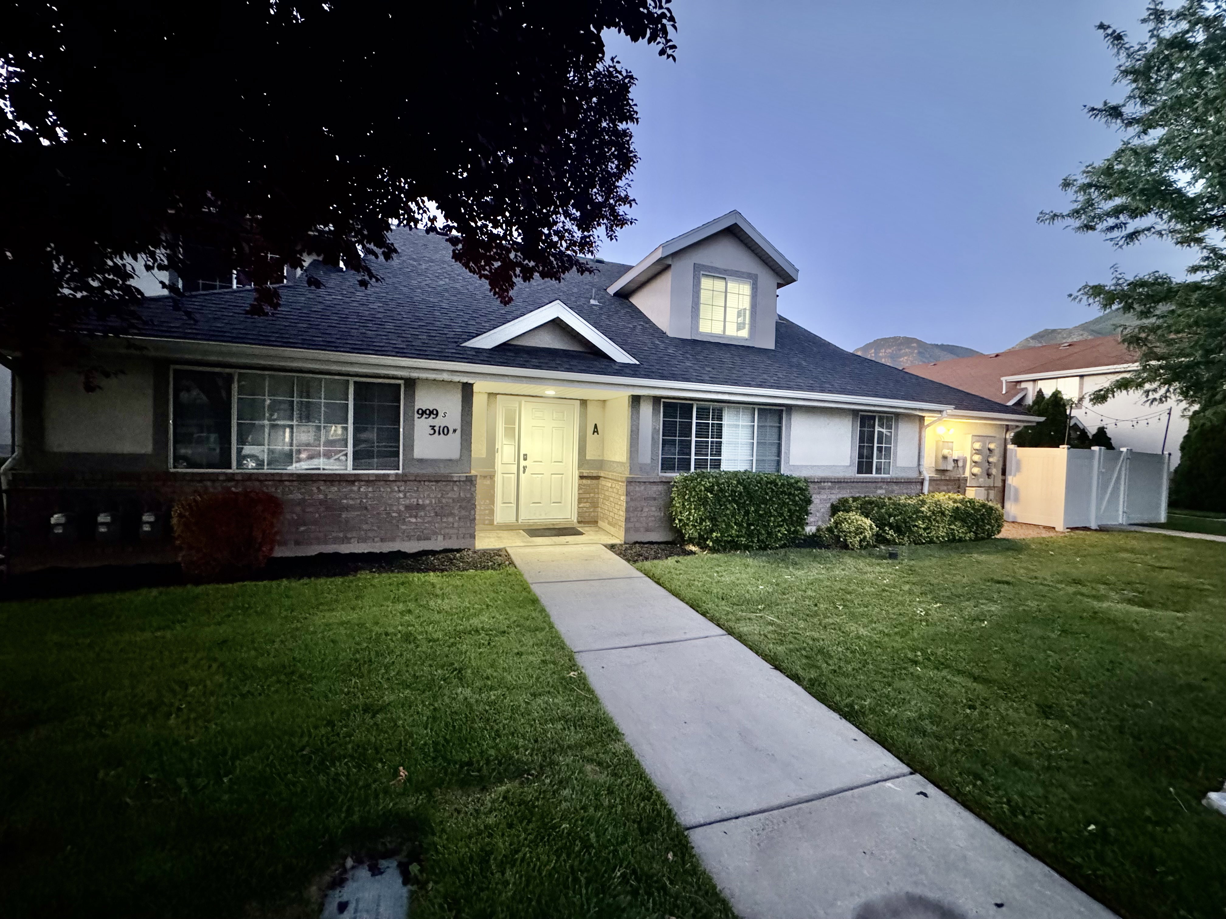 Single-story residence featuring a gray shingle roof and a prominent dormer window