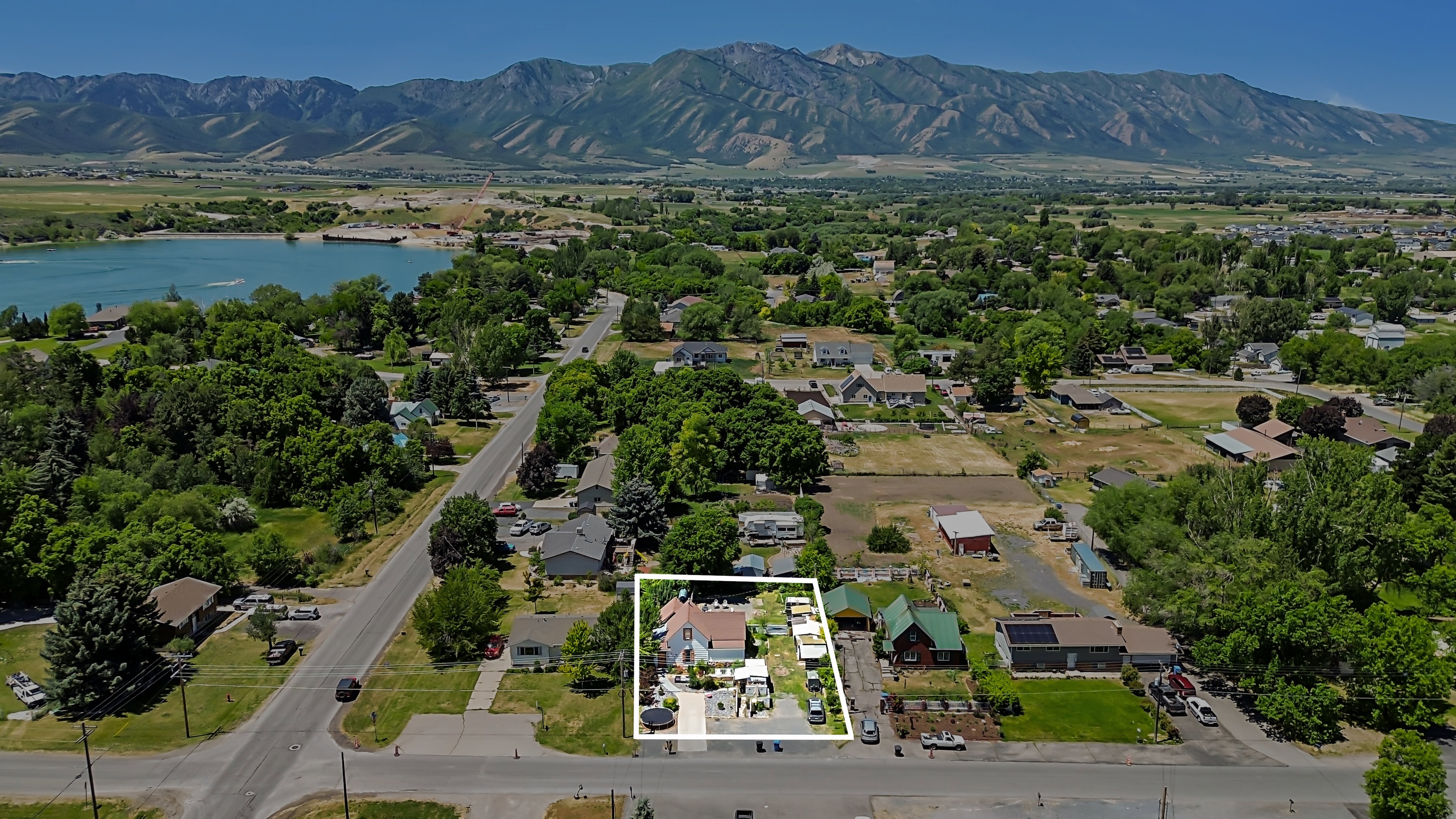 Aerial perspective showcasing the property with surrounding residential structures and mature trees