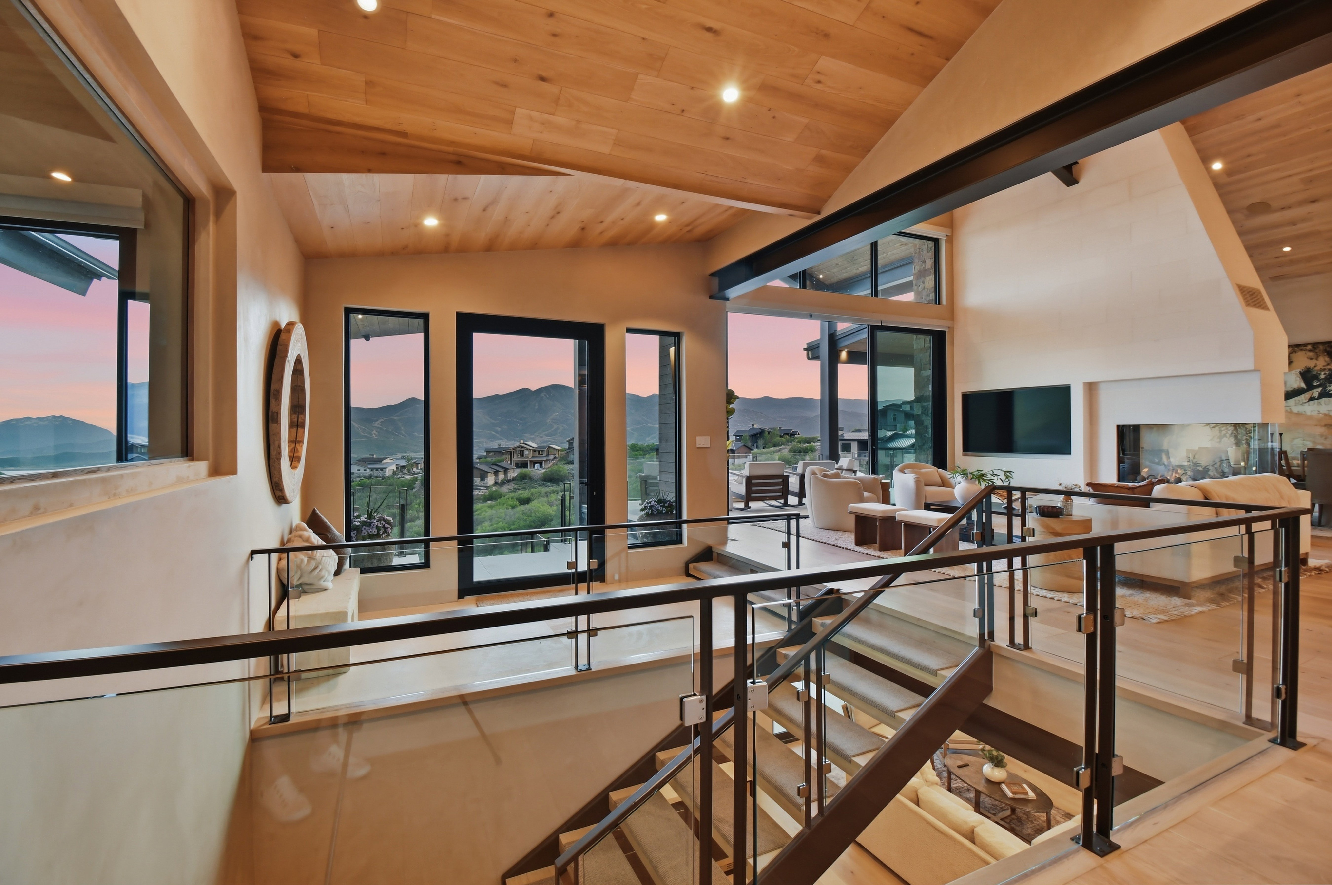 Staircase featuring glass panel railings and dark metal supports