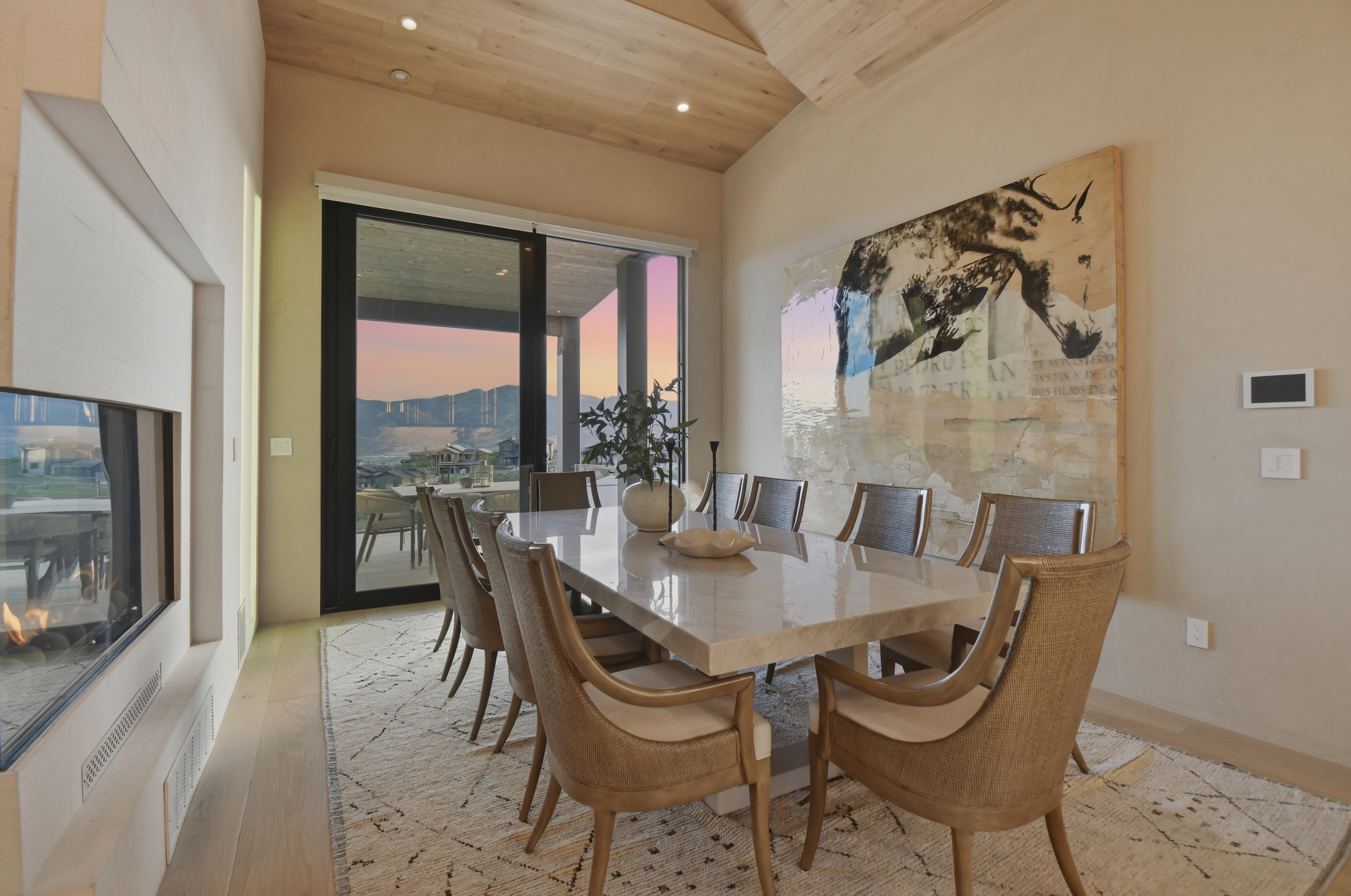 Dining area featuring a vaulted wood-paneled ceiling, light wood-finish flooring, and a linear fireplace