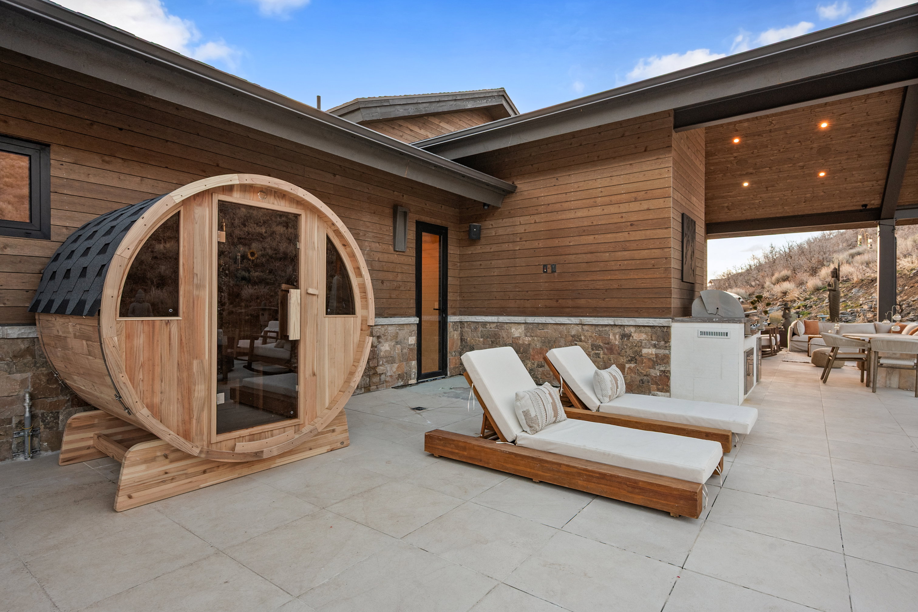 Outdoor barrel sauna on a stone patio