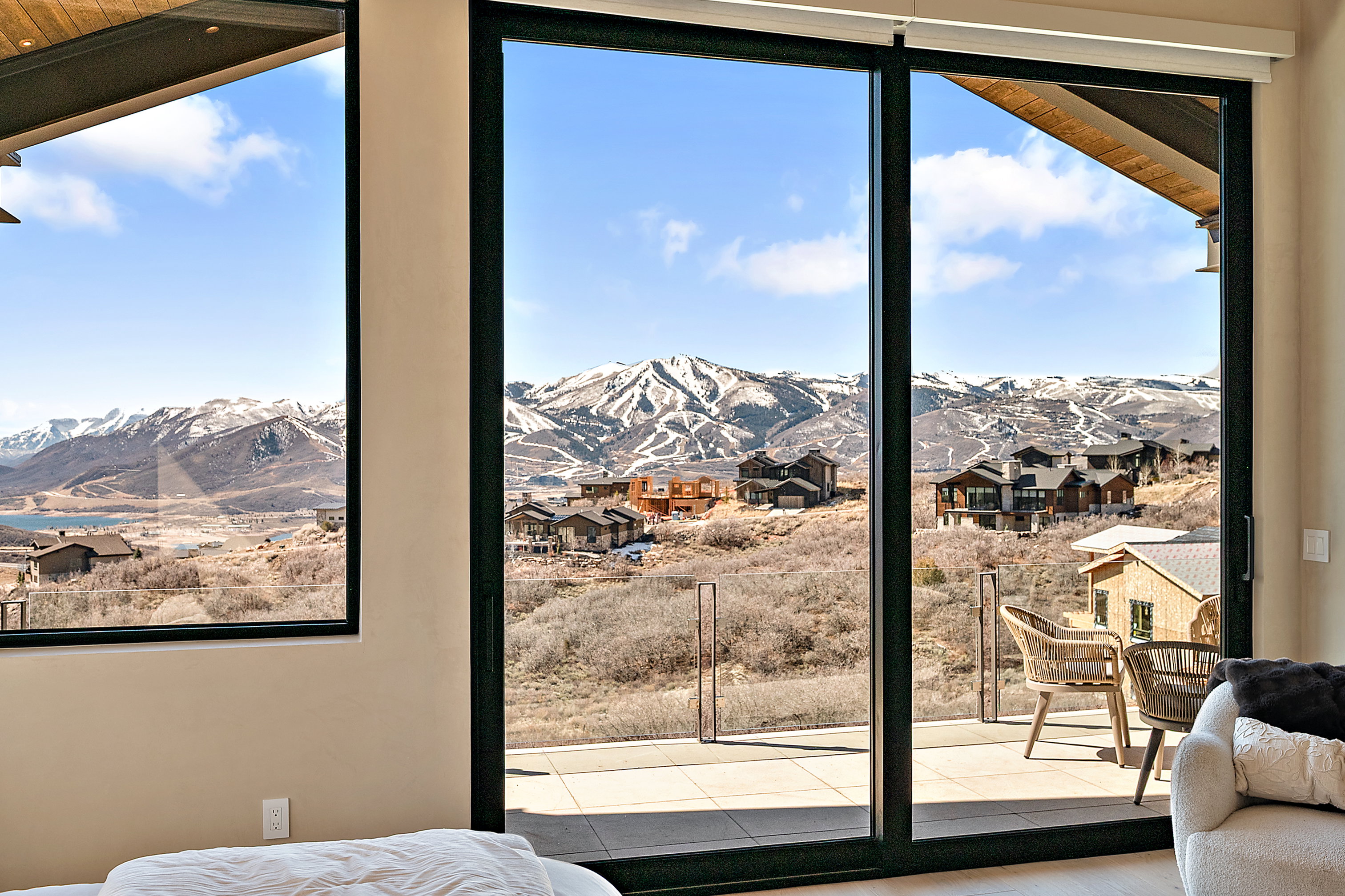 Expansive glass sliding doors open to a patio with mountain and valley scenery