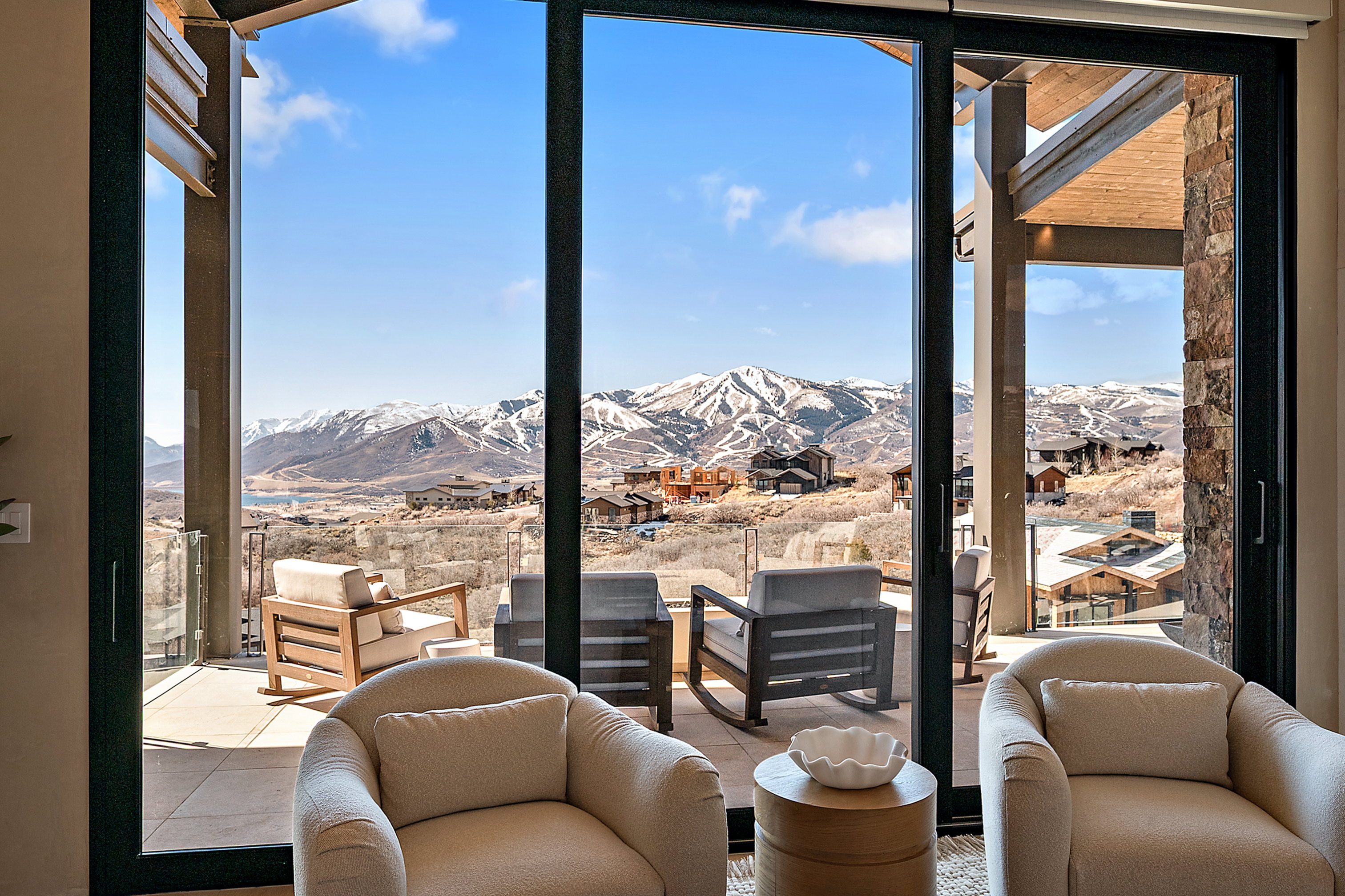 Expansive sliding glass doors opening to an outdoor patio with mountain and valley scenery