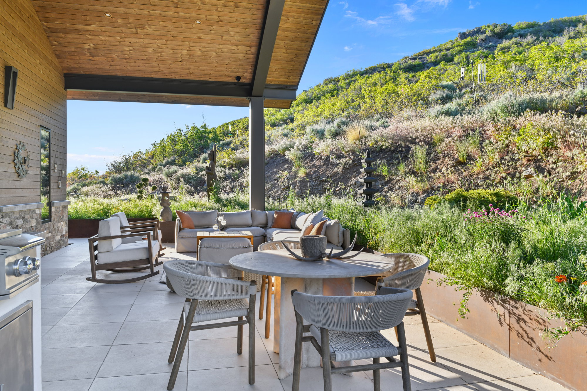 Covered patio featuring a wood-paneled ceiling and stone accent wall