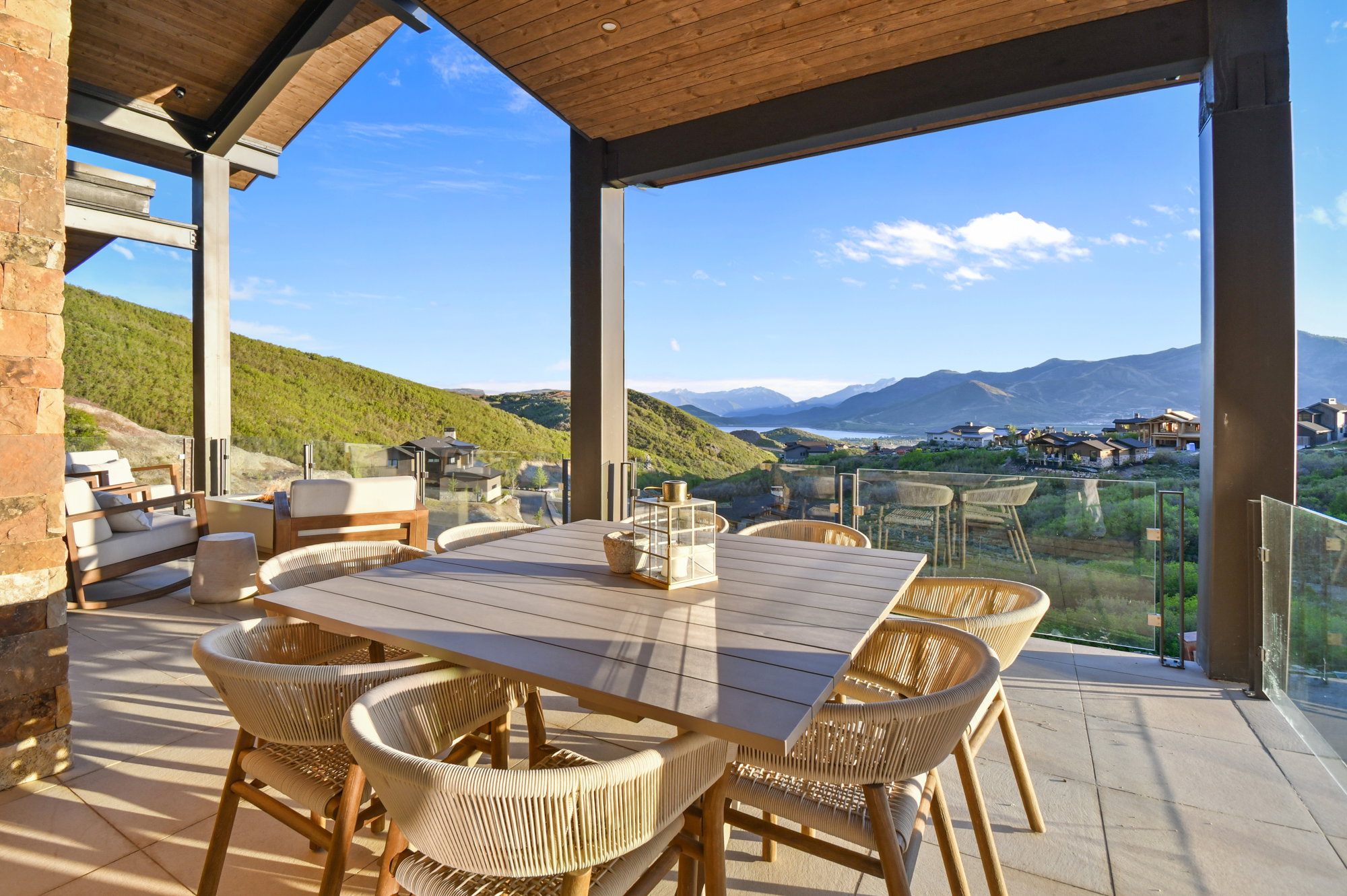 Expansive covered patio featuring a wood-panel ceiling, stone accent wall, and tiled flooring