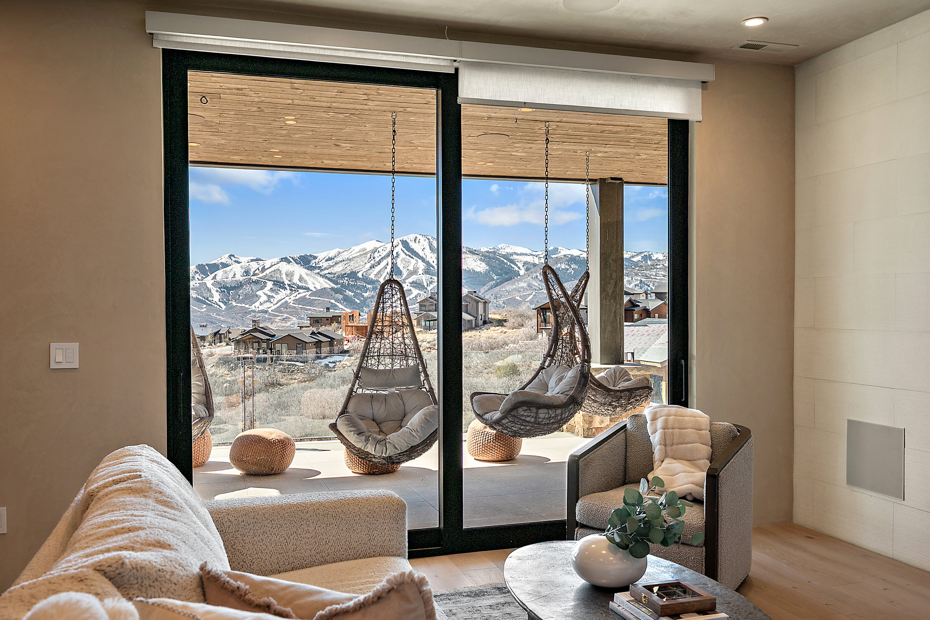 Spacious room featuring floor-to-ceiling sliding glass doors, light wood-finish flooring, recessed lighting, and a white paneled wall accent