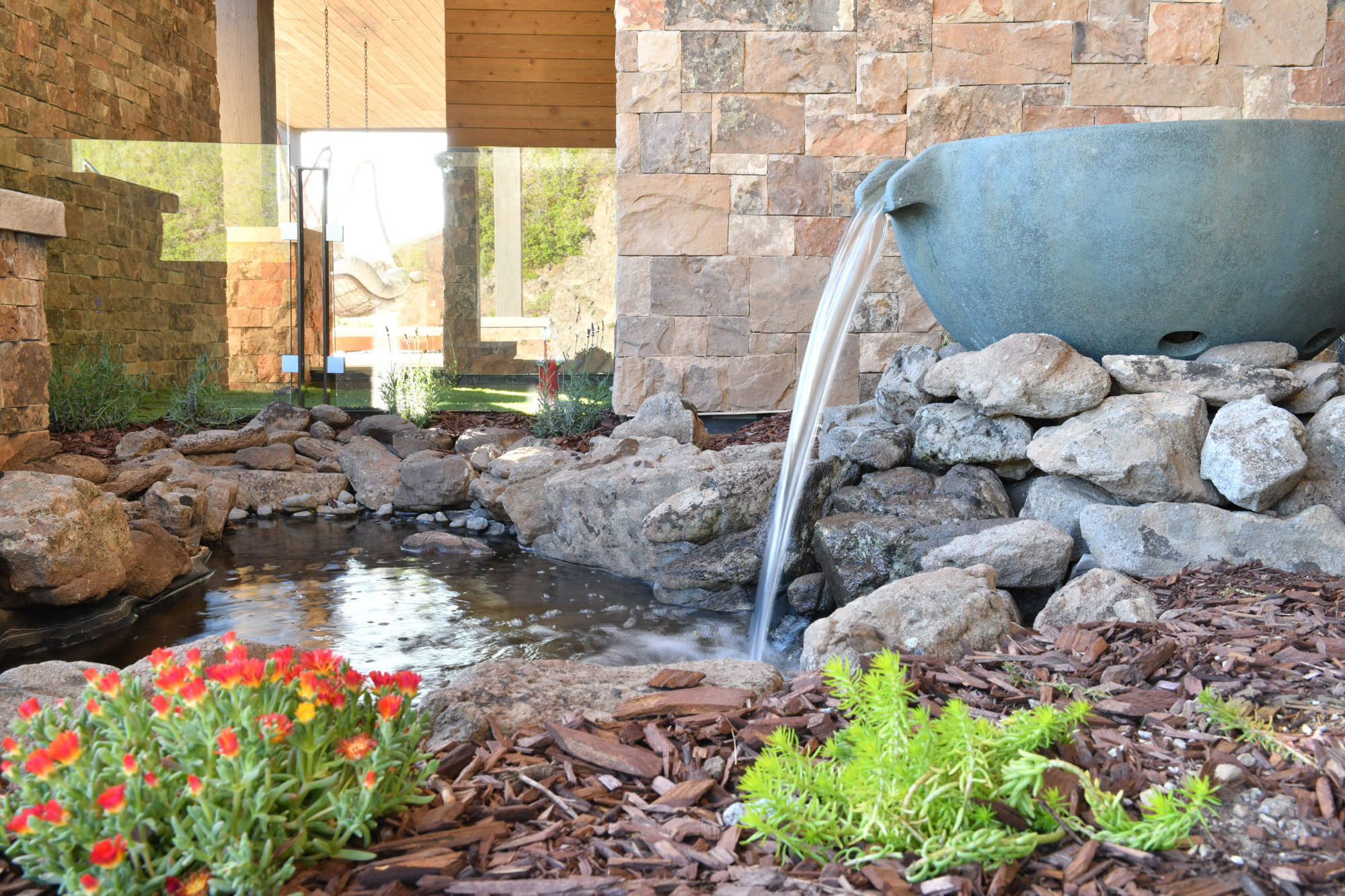 Water feature with a large basin, stone accents, and surrounding landscaping