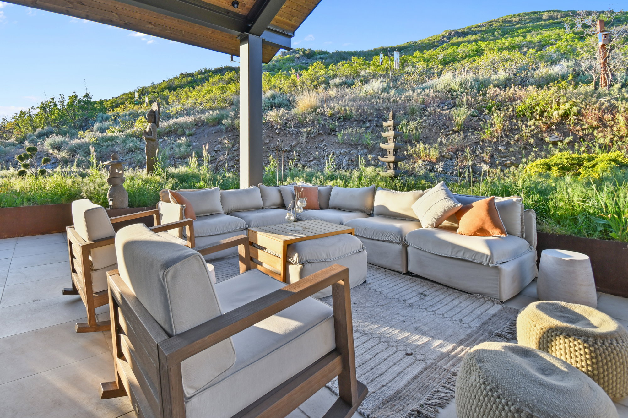 Covered outdoor patio with a concrete surface and sloped natural landscaping