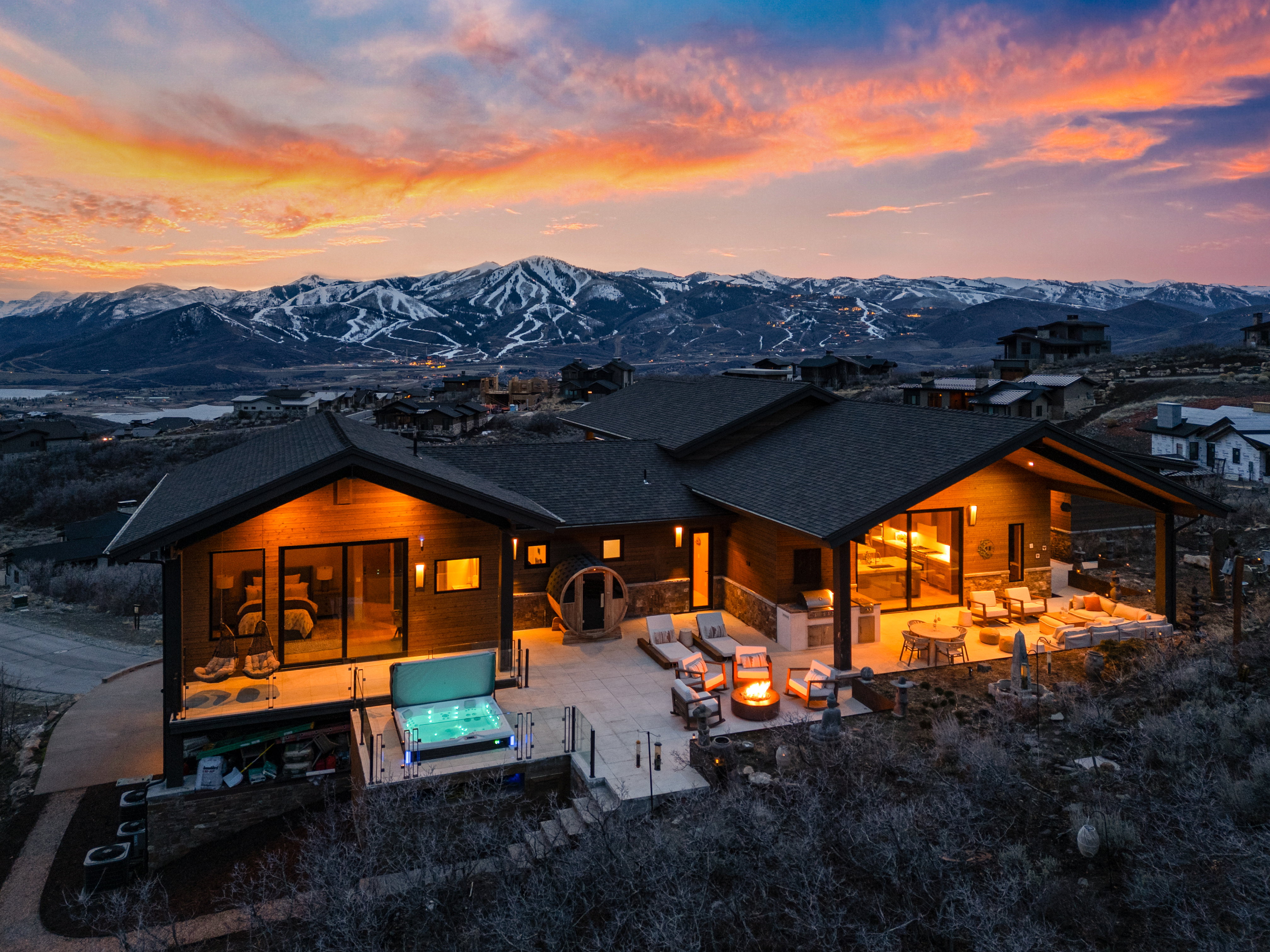 Contemporary-style residence with a large exterior patio featuring a built-in fire pit, covered outdoor living space, and a hot tub