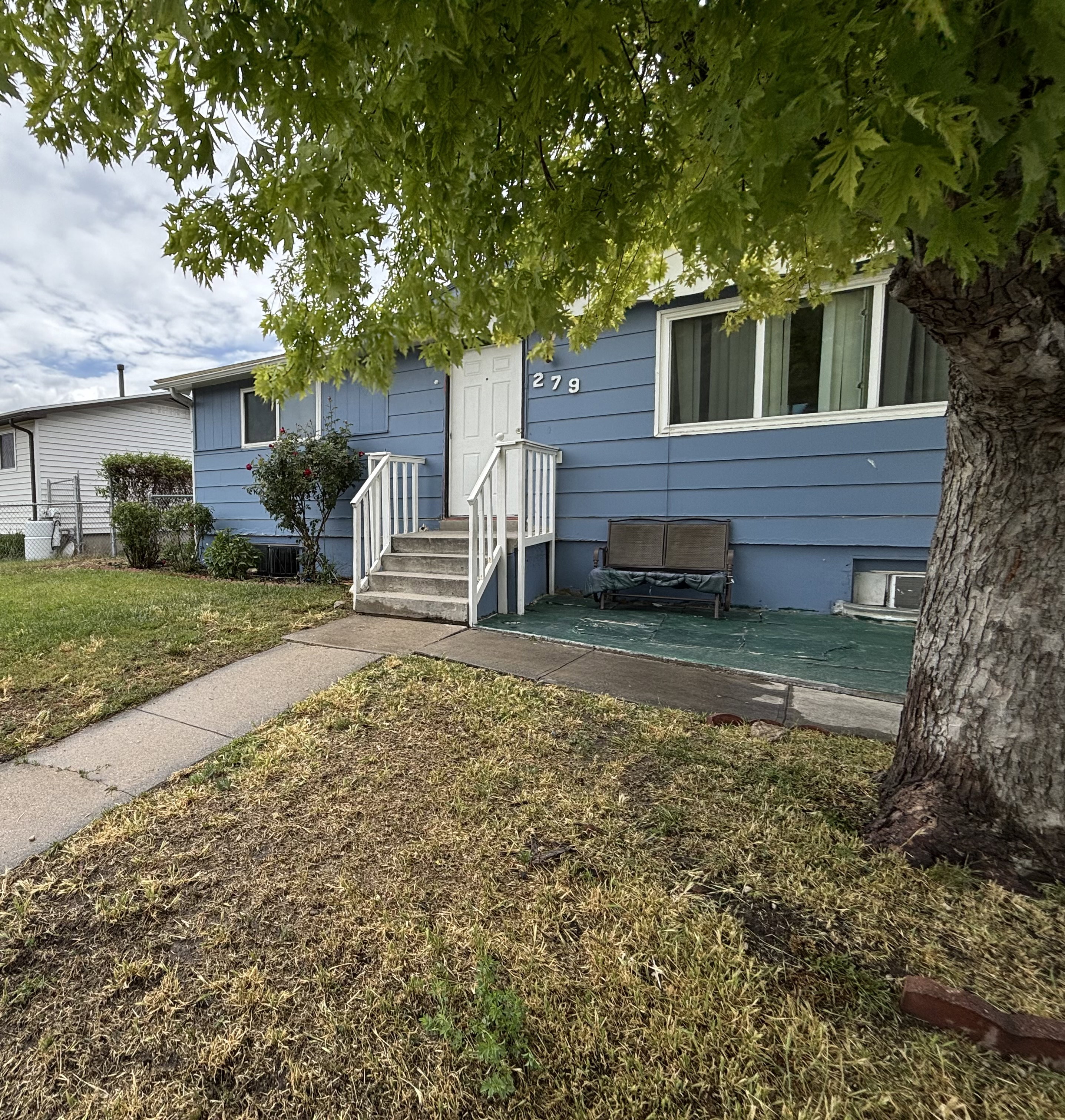 Blue siding exterior featuring white trim windows and a white front door