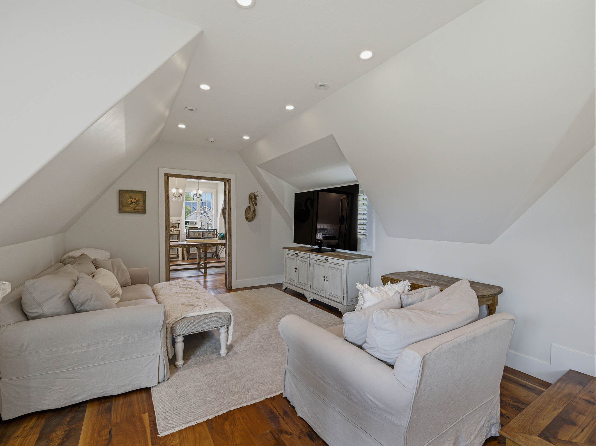 Attic living space featuring wood-finish flooring, recessed lighting, and a white media console