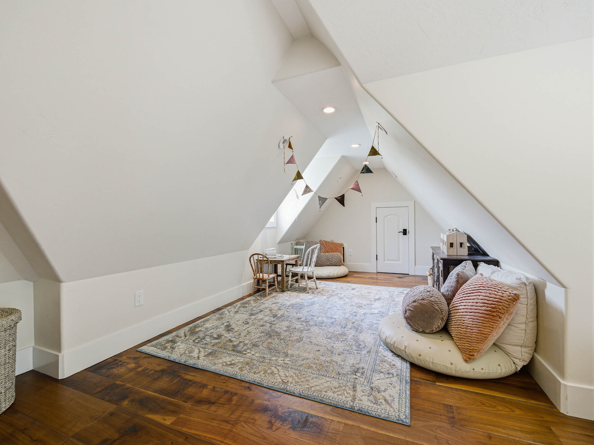 Attic space featuring wood-finish flooring, white sloped ceilings, and recessed lighting