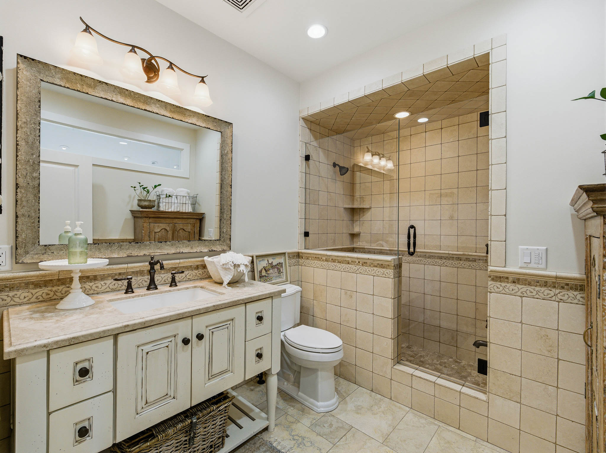 Bathroom featuring a distressed-finish single vanity with a solid surface countertop and undermount sink