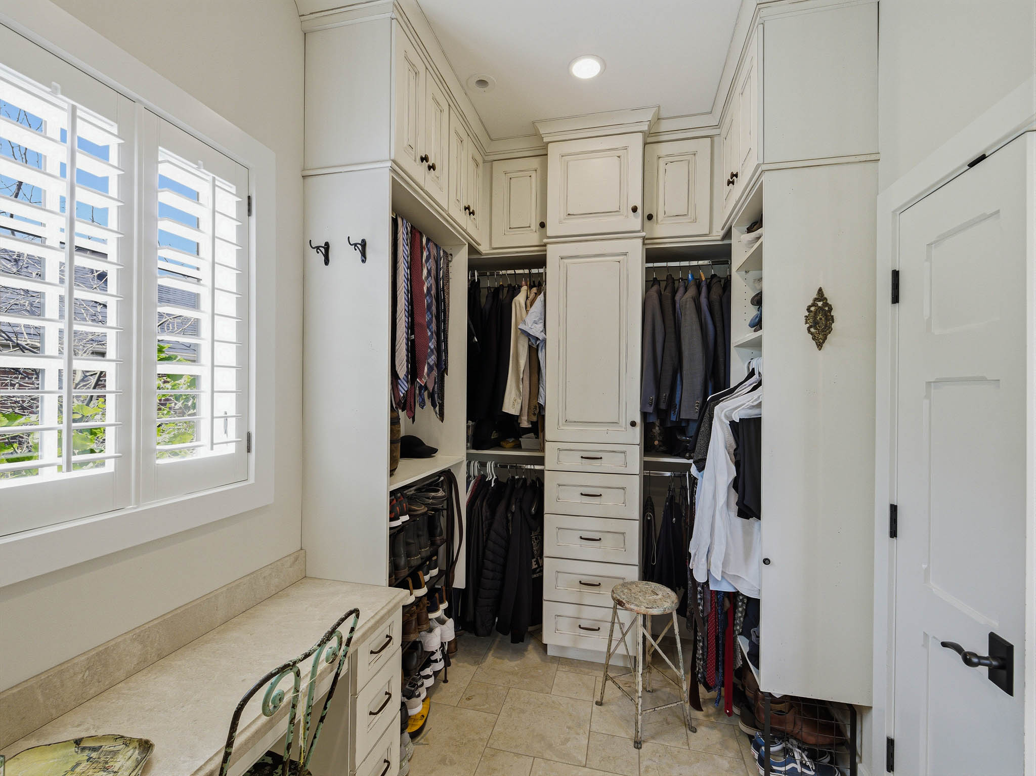 Custom closet system with built-in cabinetry, drawers, and hanging rods