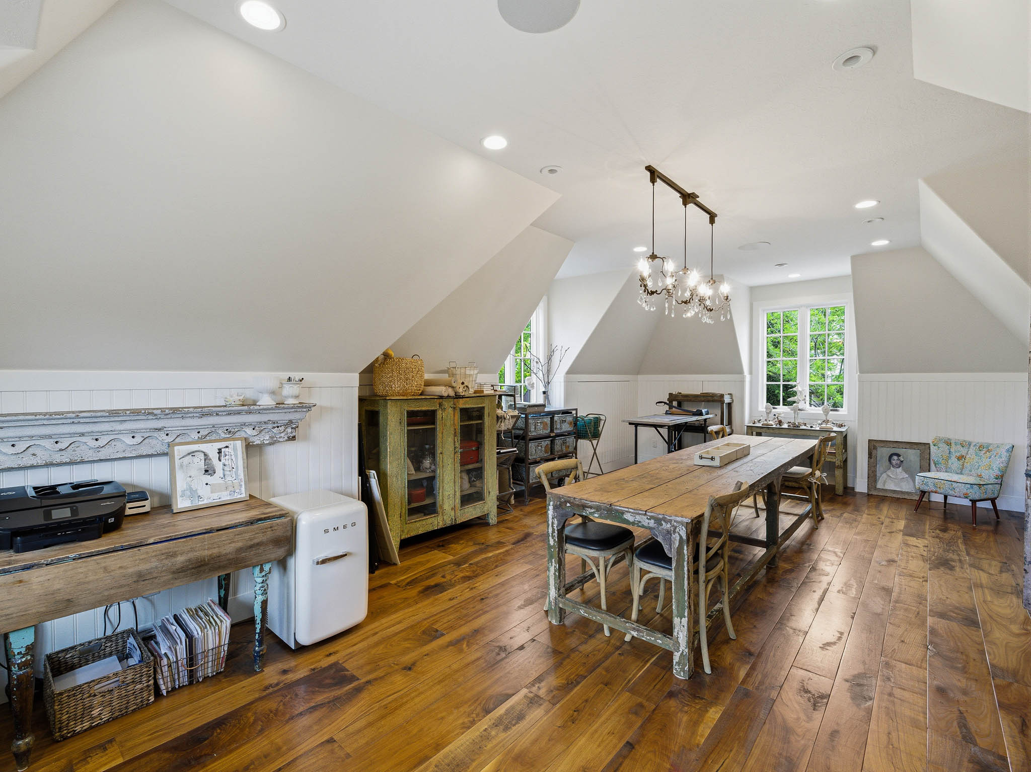Vaulted ceiling room featuring hardwood flooring and multiple windows
