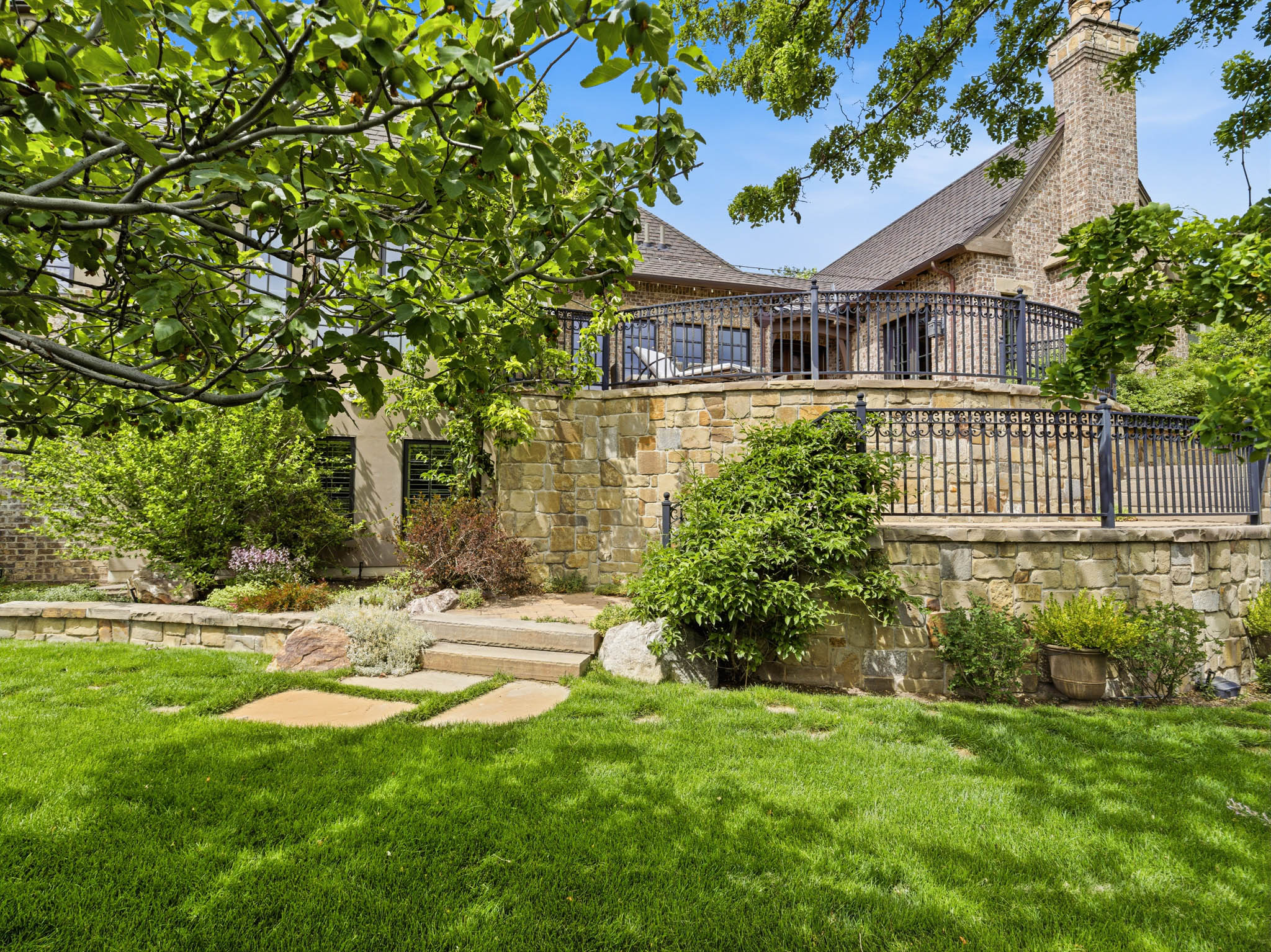 Stone-clad exterior featuring a multi-level terraced design with wrought iron railings