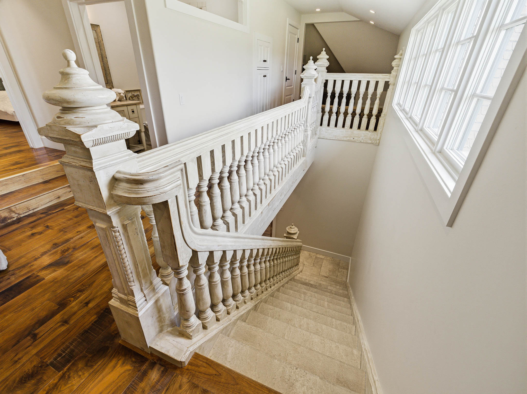 Ornate balustrade with a decorative newel post, contrasting with a light-colored stone staircase