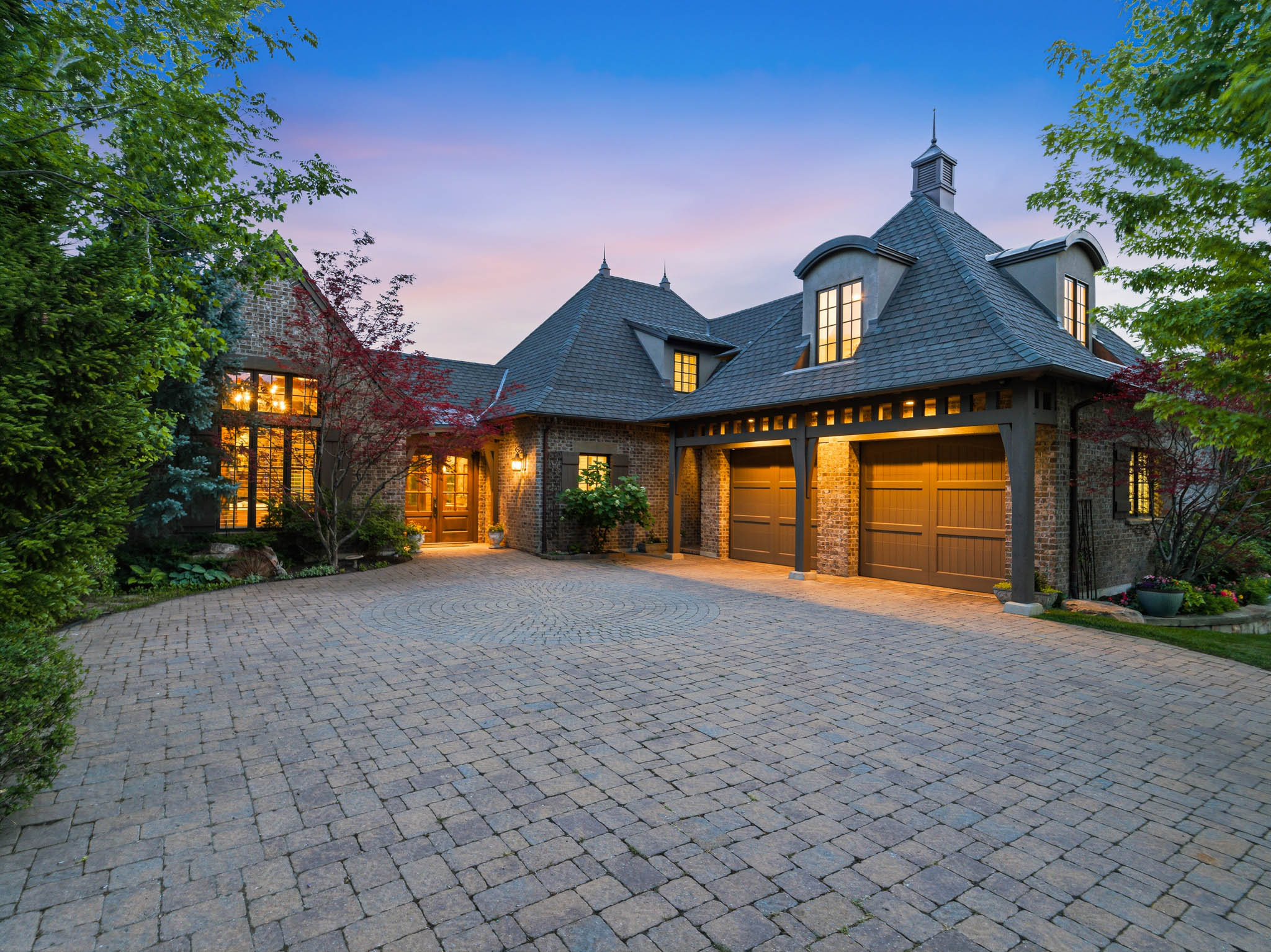 Stone and brick exterior with a large paver driveway