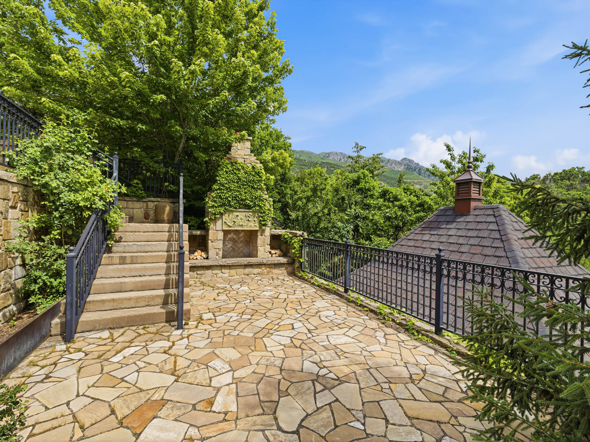 Flagstone patio with a built-in outdoor fireplace and stone retaining walls
