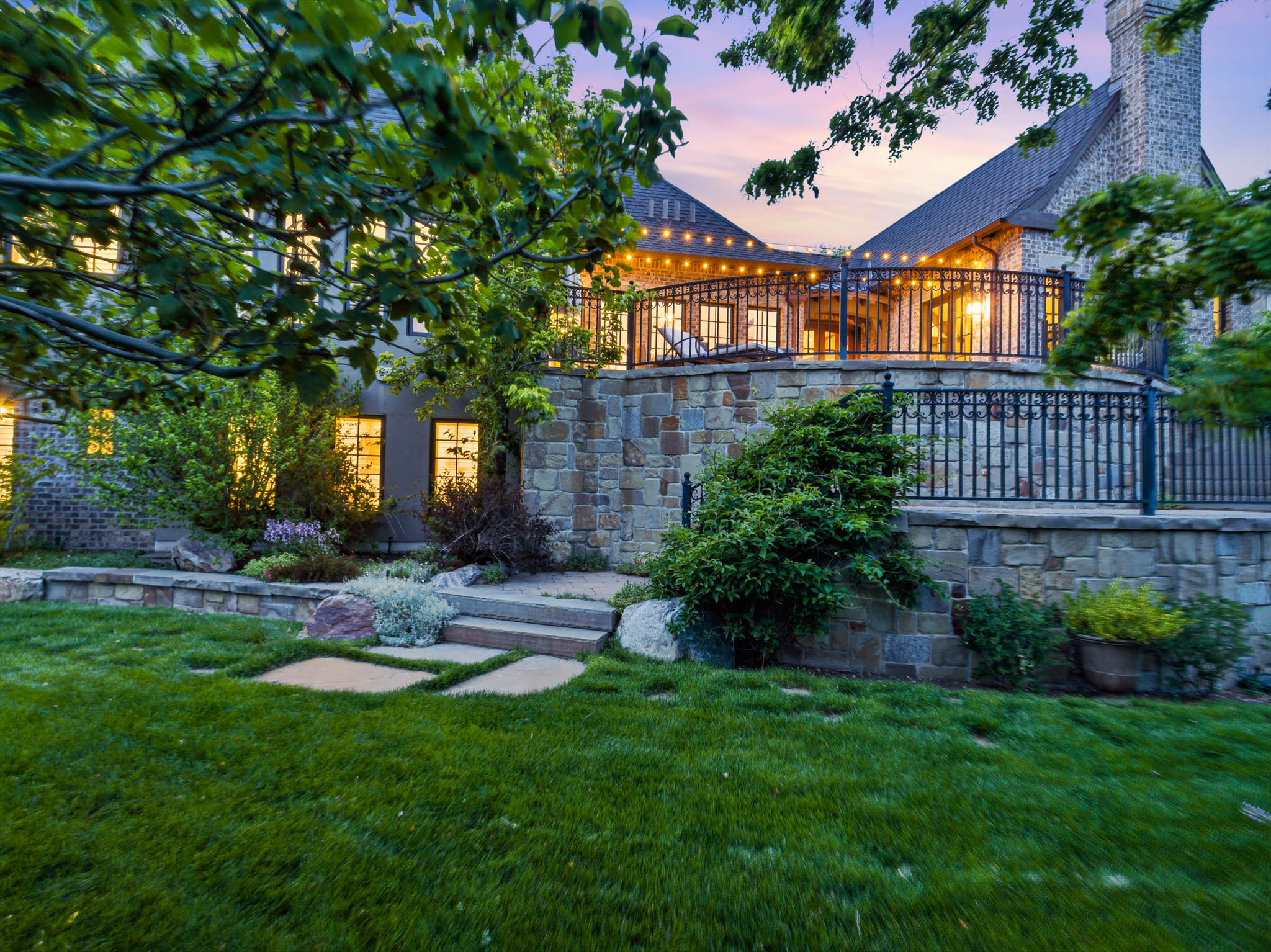 Expansive terraced yard featuring a manicured lawn and stone retaining walls