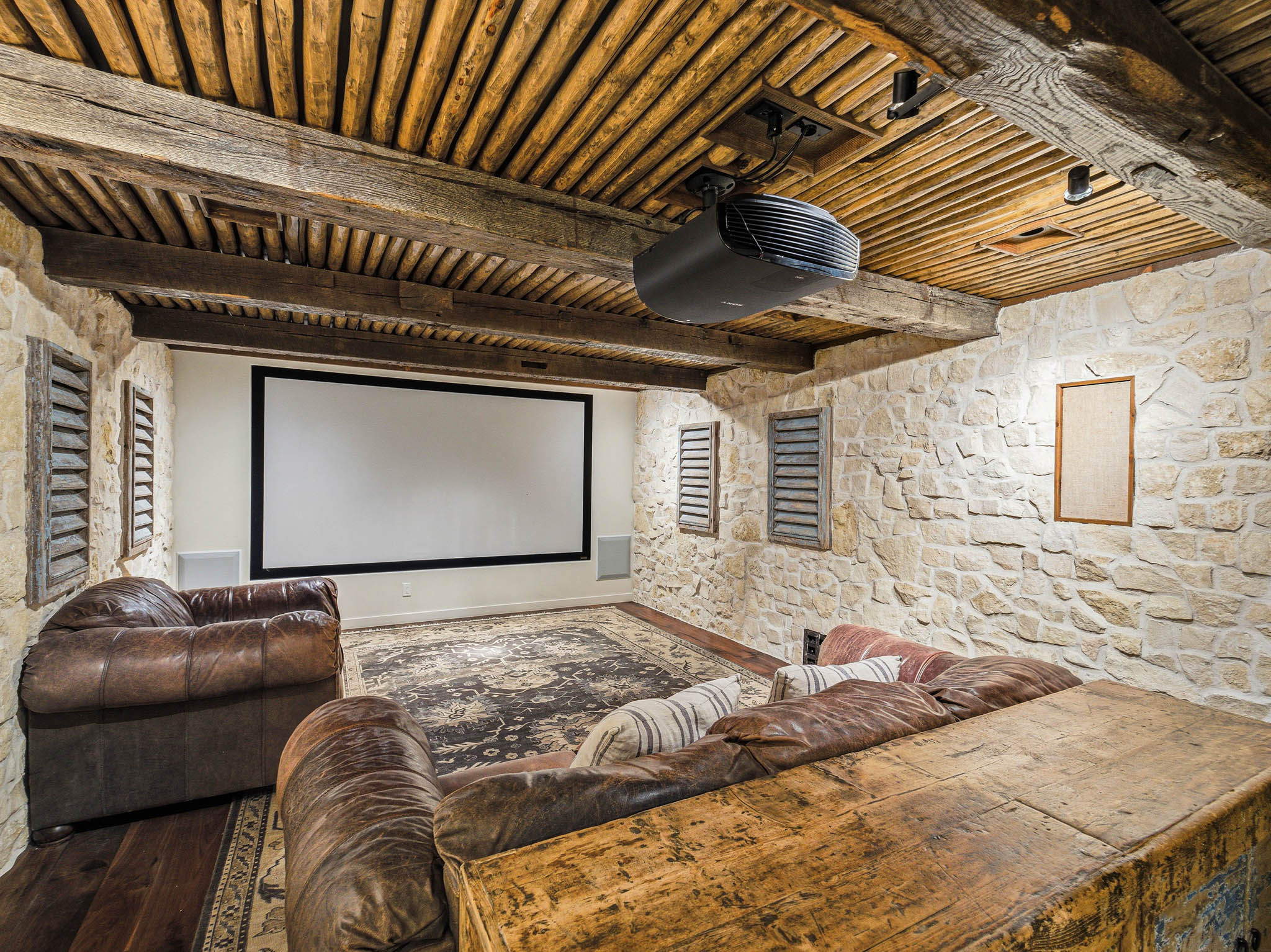 Dedicated media room featuring a large projection screen and ceiling-mounted projector