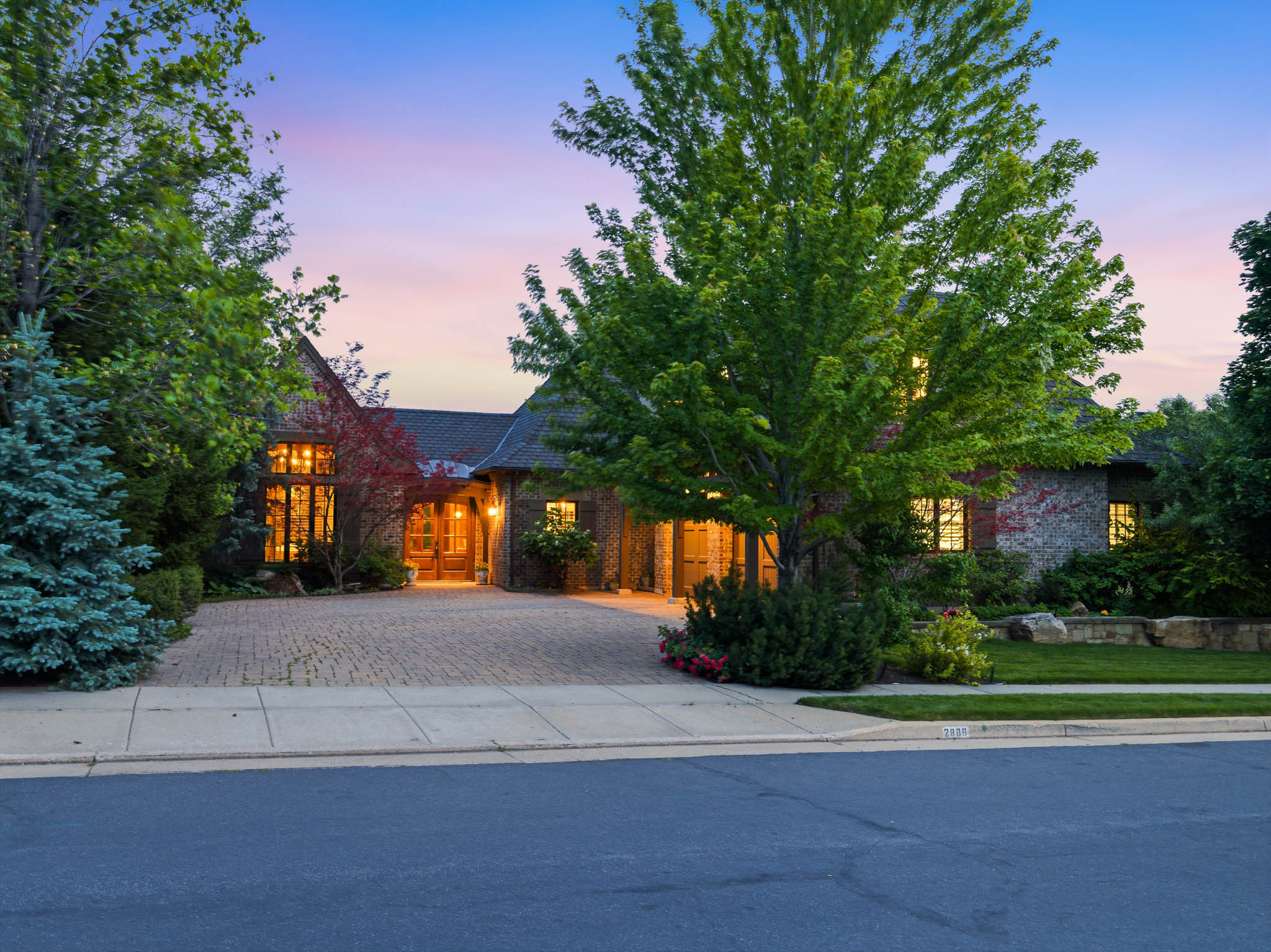 Stone and brick exterior with a large paver driveway