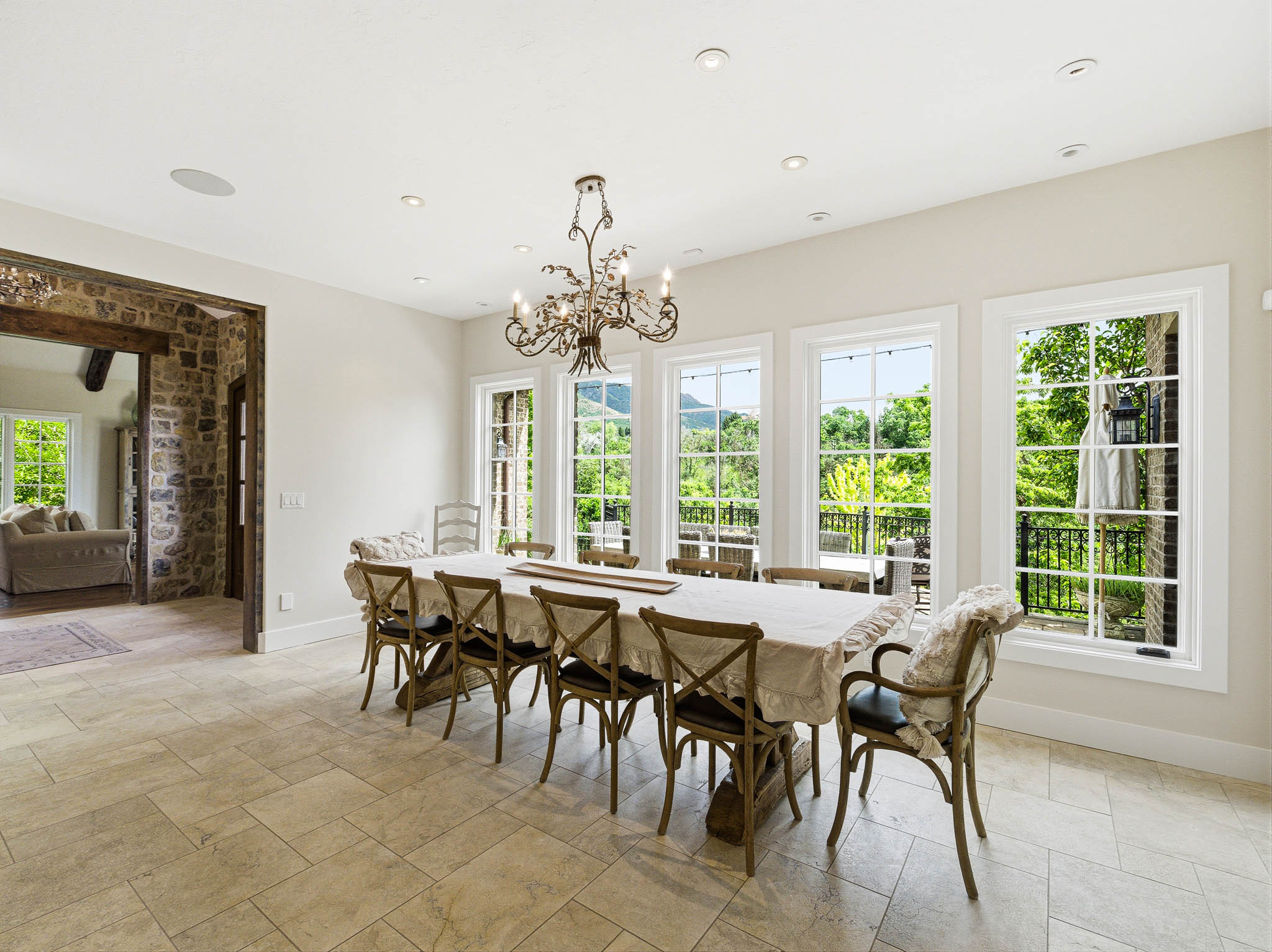 Spacious dining room featuring a decorative chandelier, recessed lighting, and large multi-pane windows