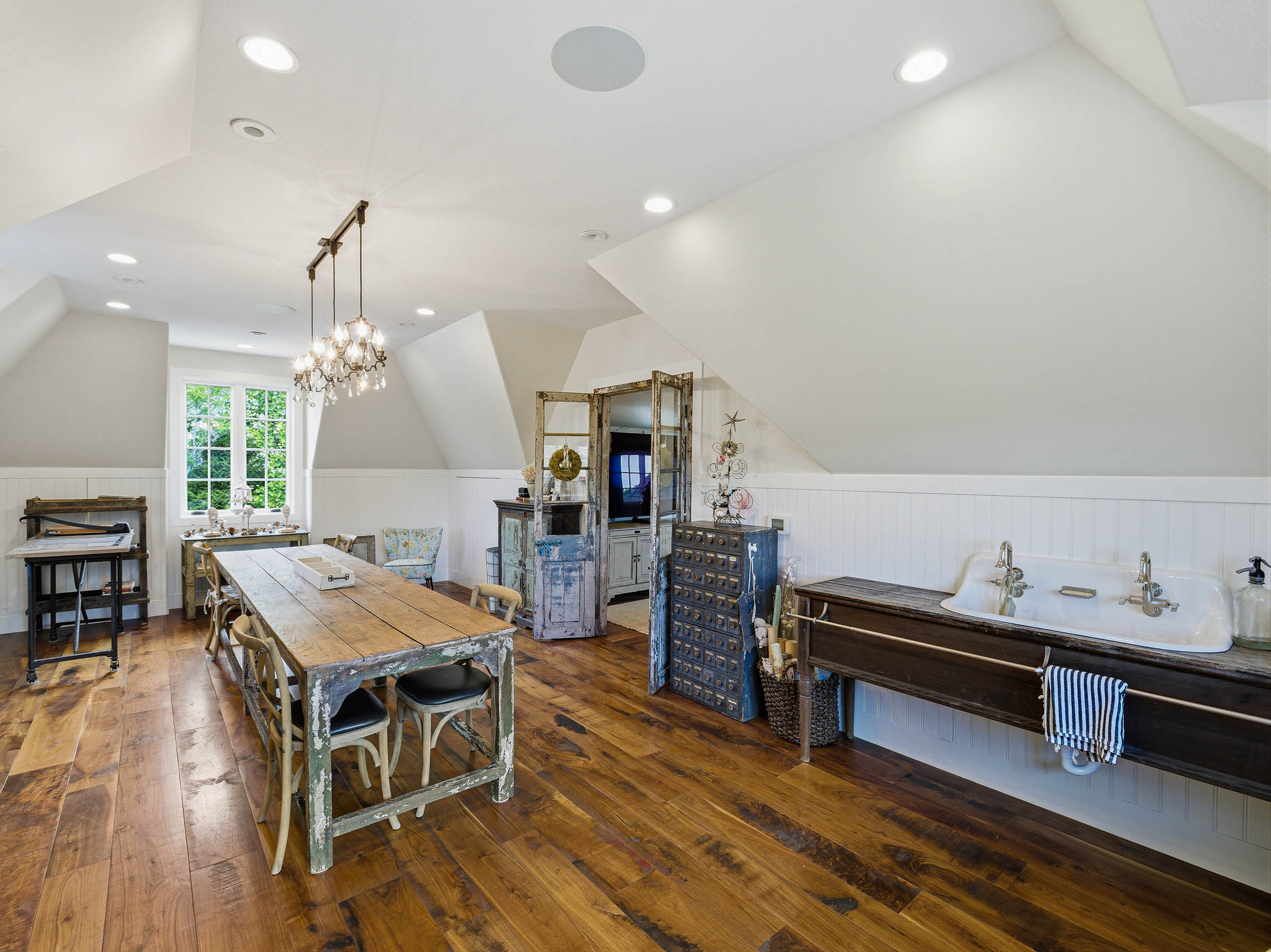Spacious room featuring wood-finish flooring, white beadboard wainscoting, and recessed lighting