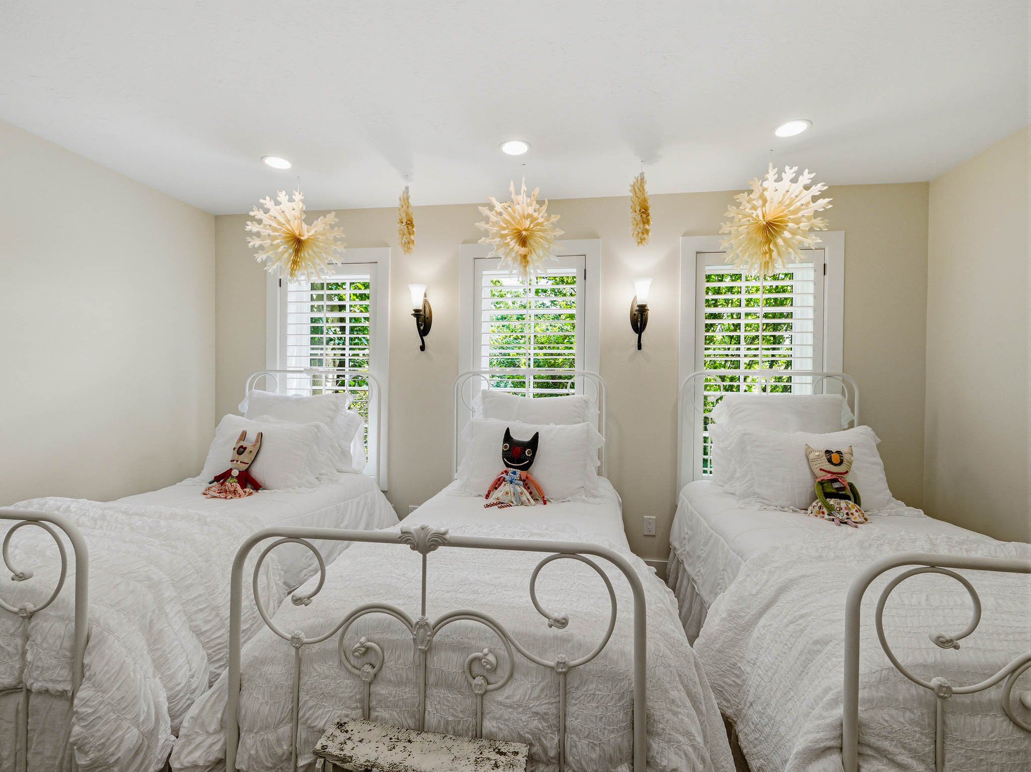 Room with three windows featuring plantation shutters and exterior tree views