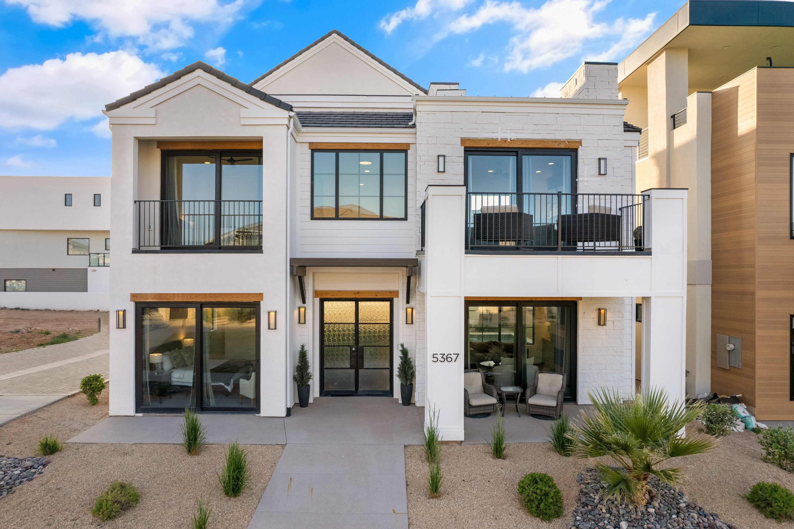 Modern stucco and brick exterior featuring a prominent two-story design