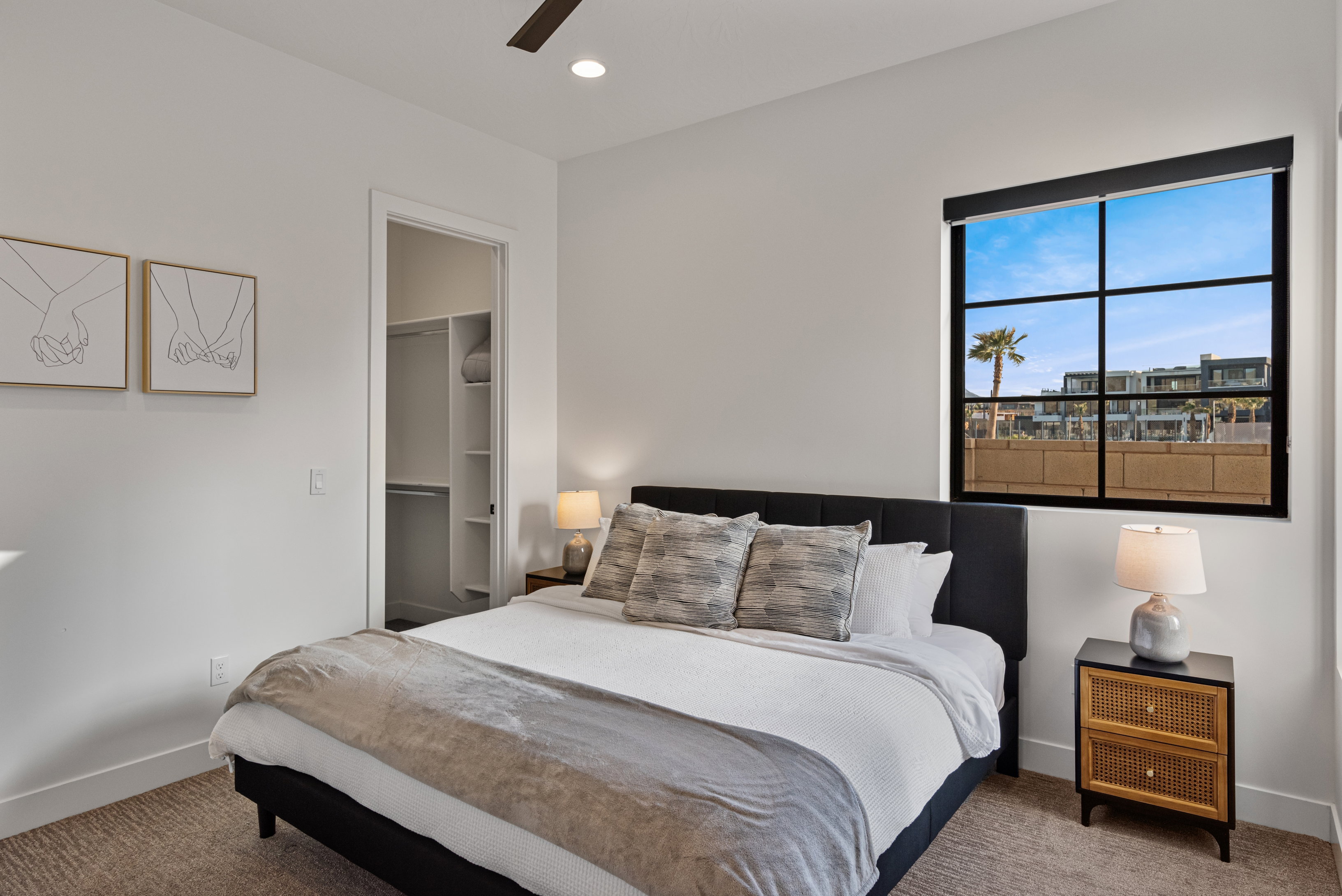Carpeted bedroom featuring a large window with black grid panes, a built-in closet with shelving, a ceiling fan, and recessed lighting