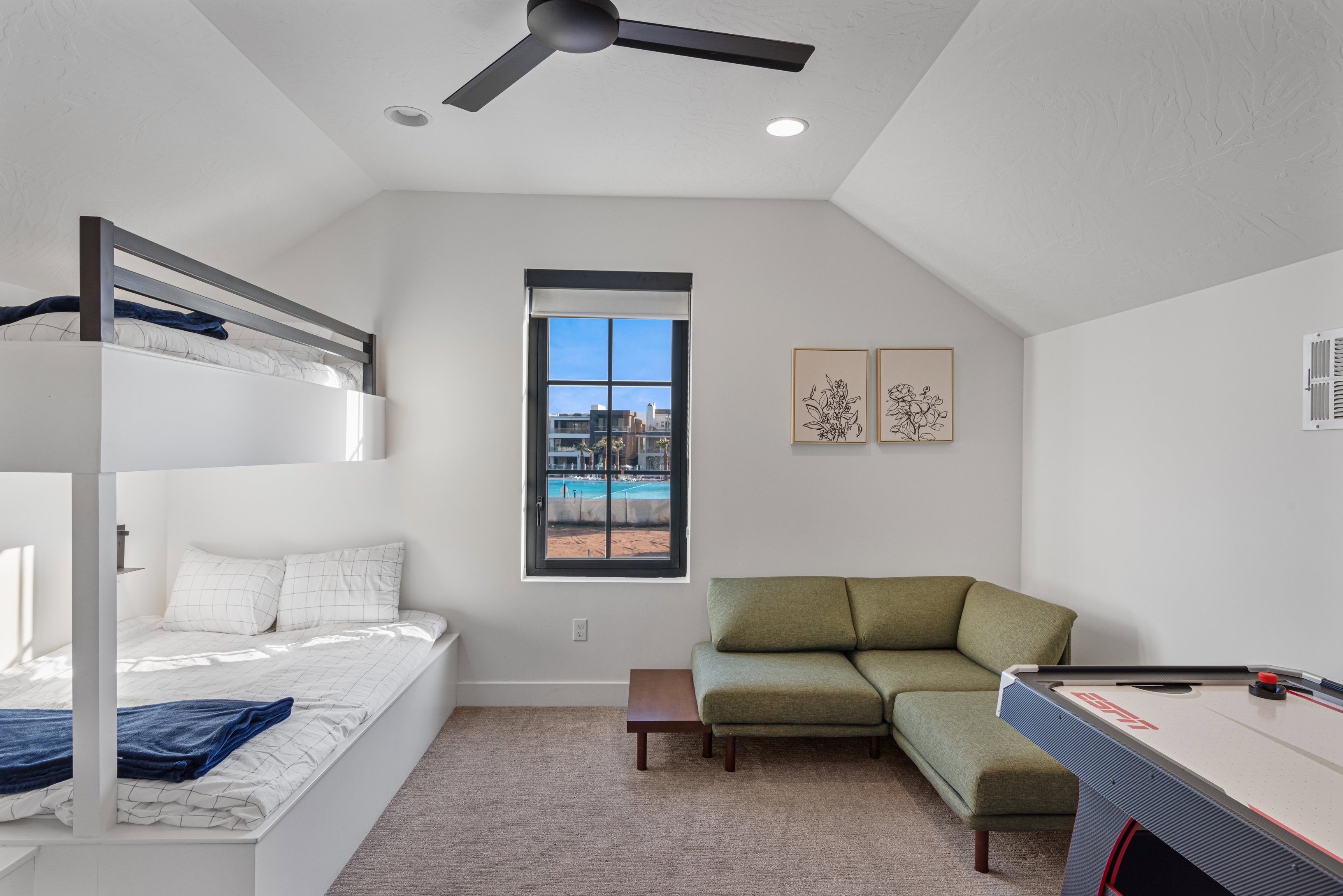 Spacious room featuring vaulted ceilings, a built-in bunk bed system, and a window with black grid panes
