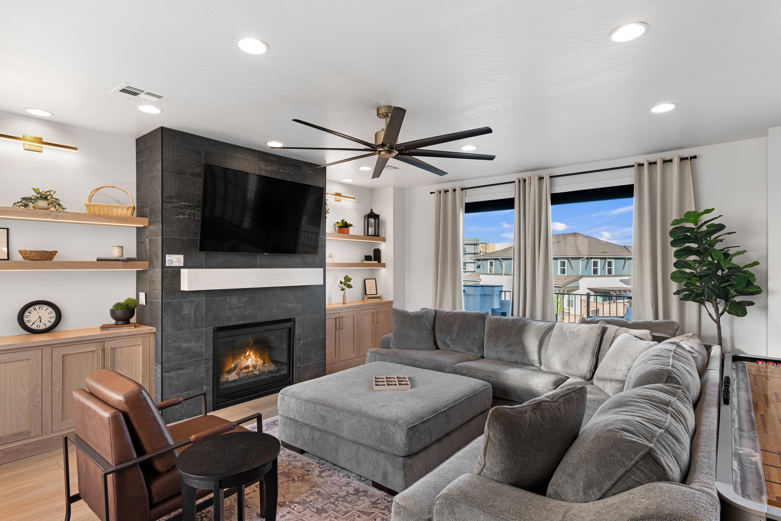 Living area featuring a floor-to-ceiling fireplace with dark tile surround and a natural wood mantel