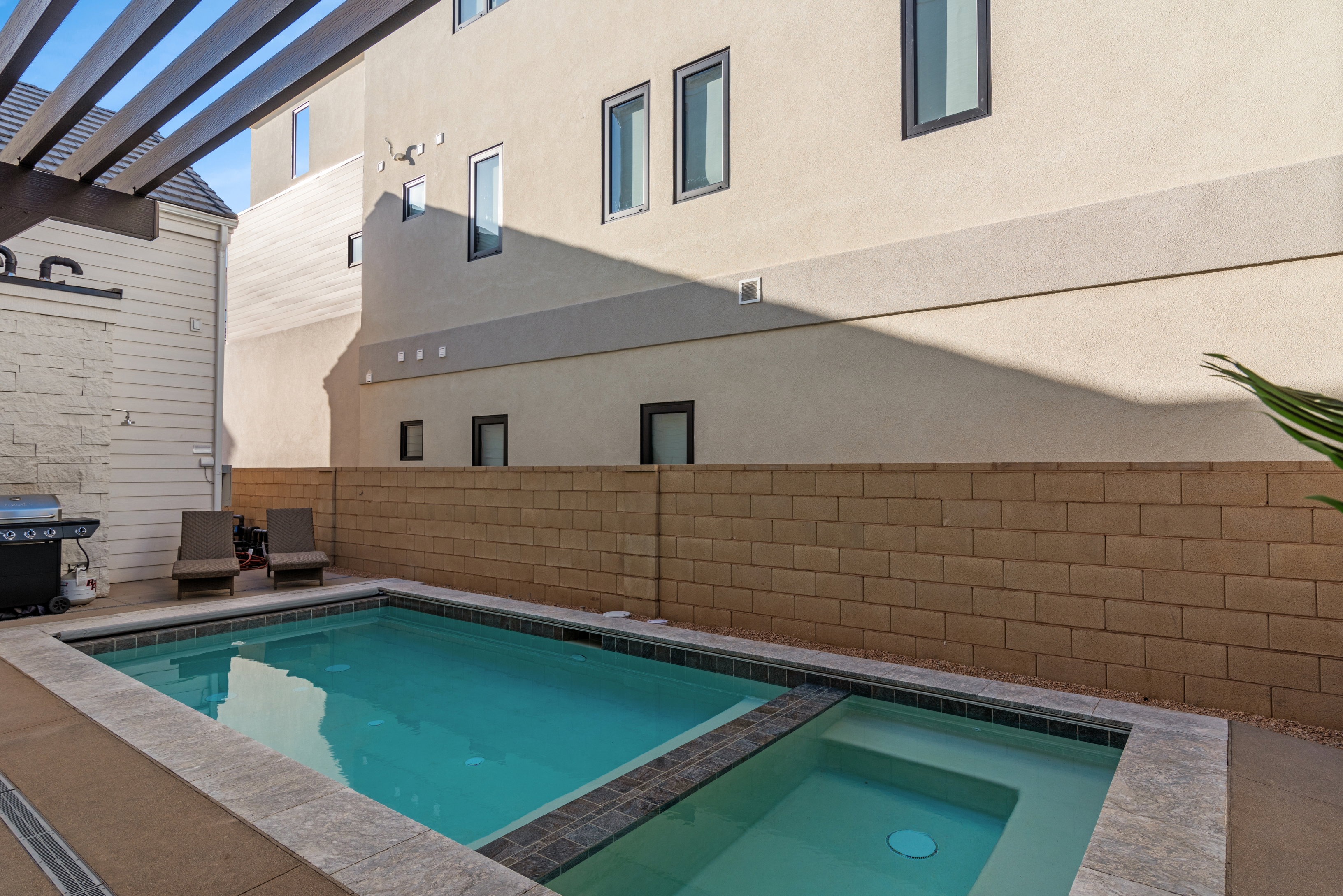 Private backyard featuring a swimming pool with an integrated spa