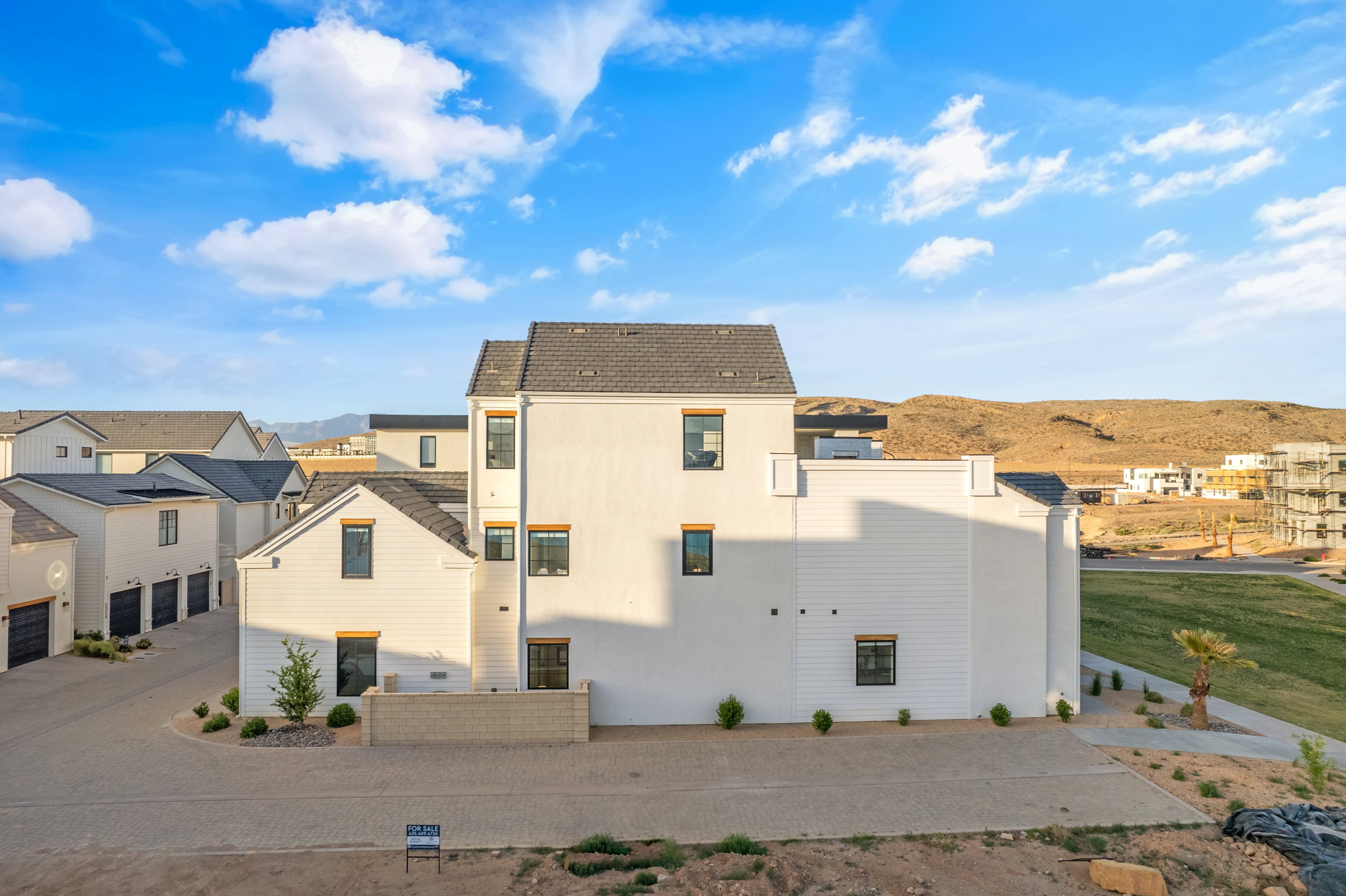 Modern multi-story property featuring white siding and a dark shingled roof