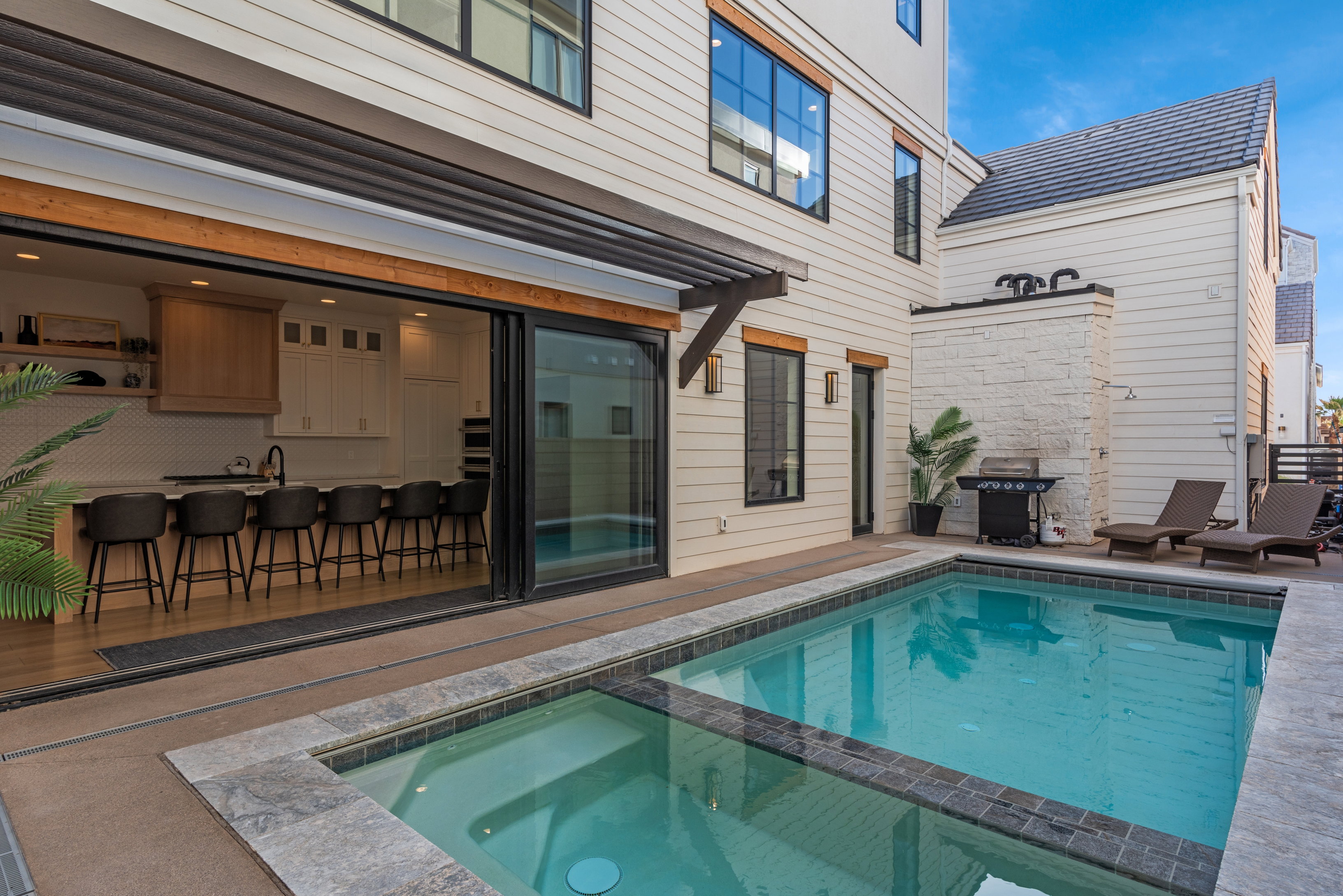 Outdoor living space featuring a rectangular swimming pool with integrated spa